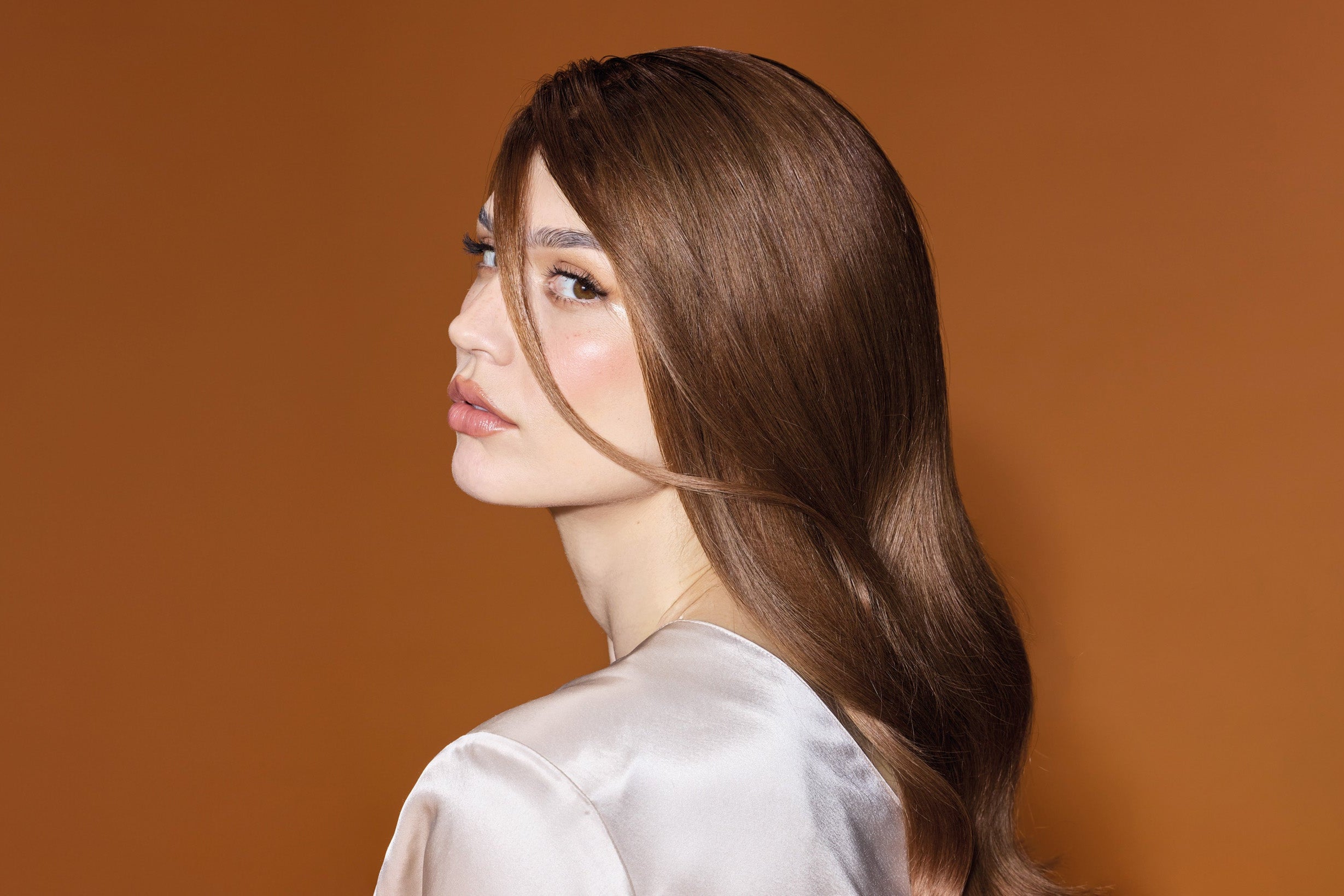 Close-up of woman with smooth, glossy hair achieved with BHBD Shine Tone treatment.