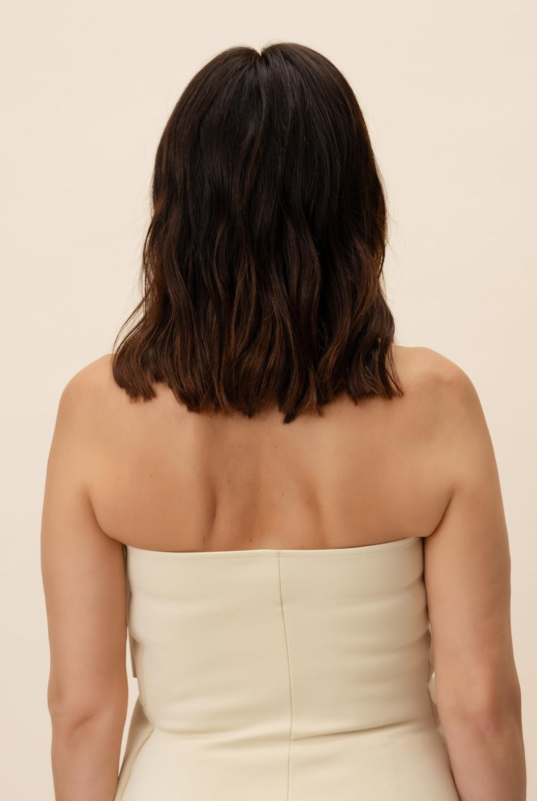 Celosia Wig 30 cm Remy human-hair wig with dark brown roots and subtle lighter lengths, softly layered and shown from the back on model.