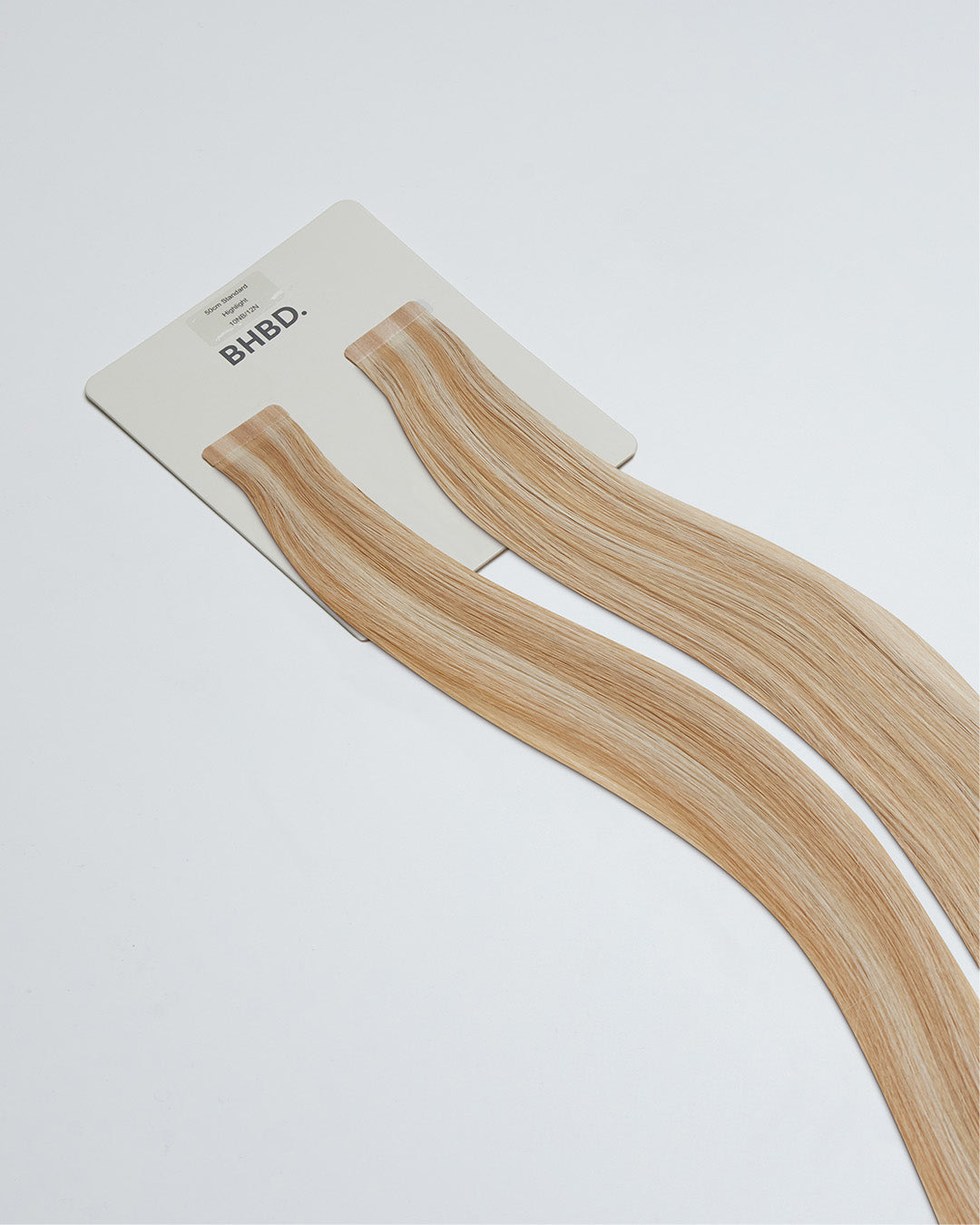 Tape Extensions 10NB/12N – pre-taped Remy human hair extensions in light beige blonde blended with natural blonde; seamless, soft and tangle-free; comes in 35cm, 50cm, and 60cm. 100% Remy hair, gentle extensions