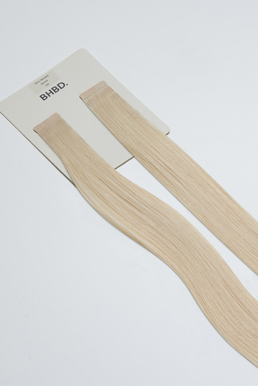 Tape Extensions 12N – pre-taped Remy human hair extensions in light natural blonde shade; seamless, soft and tangle-free; comes in 35cm, 50cm, and 60cm. 100% Remy hair, gentle extensions.