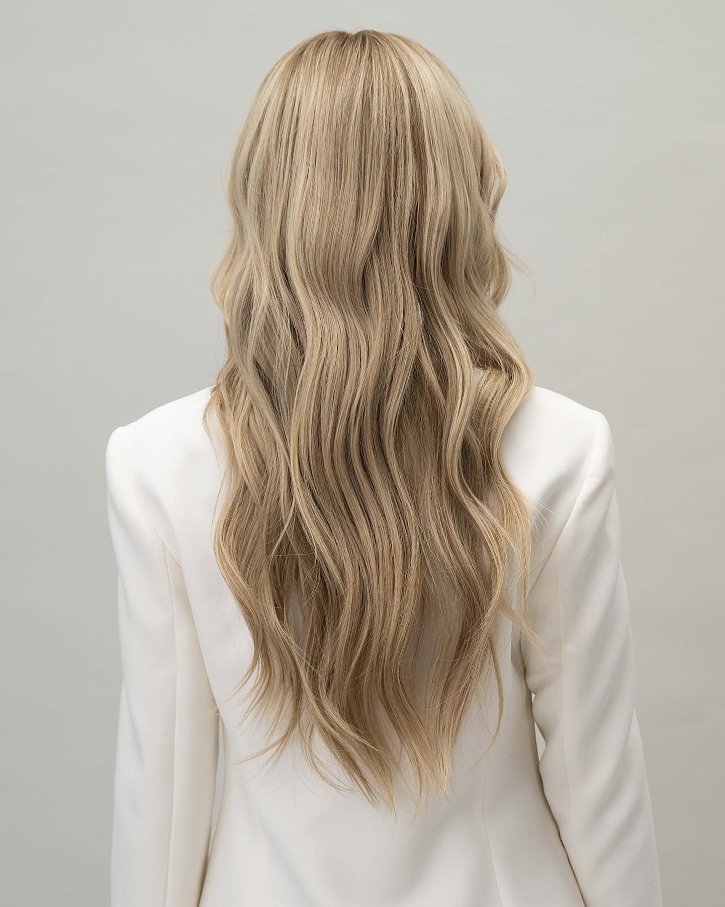 Scarlet Wig 50 cm Remy human hair wig with darker blonde roots blending into natural blonde lengths with lowlights, shown from back.