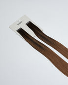 Tape Extensions 3N/6NG – pre-taped Remy human hair extensions in deep natural brown and neutral golden brown blend; seamless, soft and tangle-free; comes in 35cm, 50cm, and 60cm. 100% Remy hair, gentle extensions.