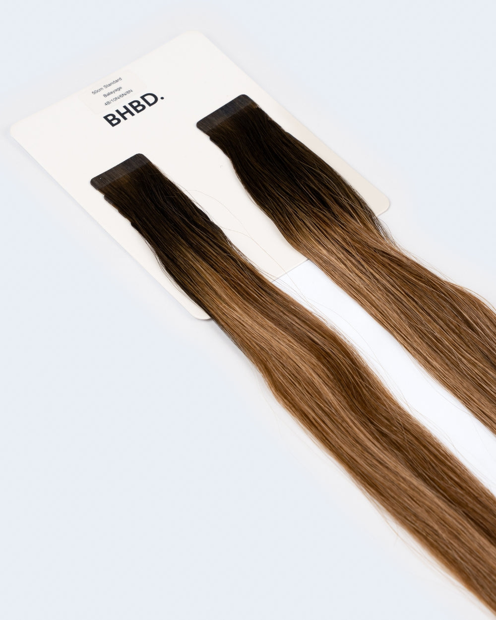 BHBD Tape Extensions 4B/10N/6N/8N – pre-taped Remy human hair extensions in mixed brunette and blonde shades; seamless, soft and tangle-free; comes in 35cm, 50cm, and 60cm. 100% Remy hair, gentle extensions.