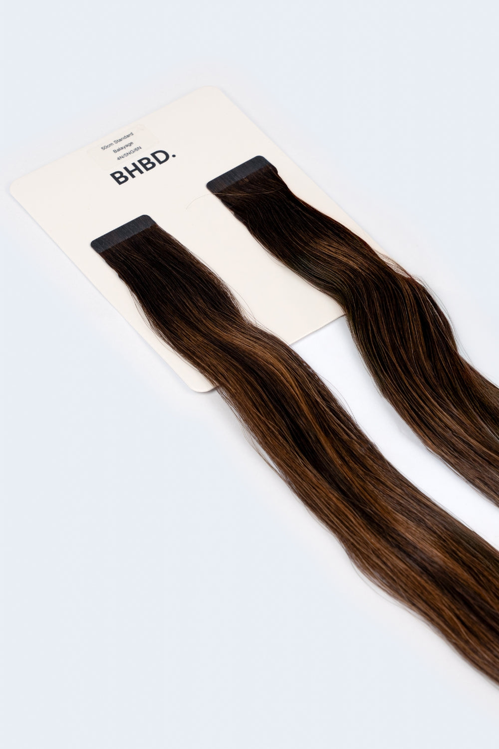 BHBD Tape Extensions 4N/5NG/6N – pre-taped Remy human hair extensions in deep brown and neutral blonde tones; seamless, soft and tangle-free; comes in 35cm, 50cm, and 60cm. 100% Remy hair, gentle extensions.