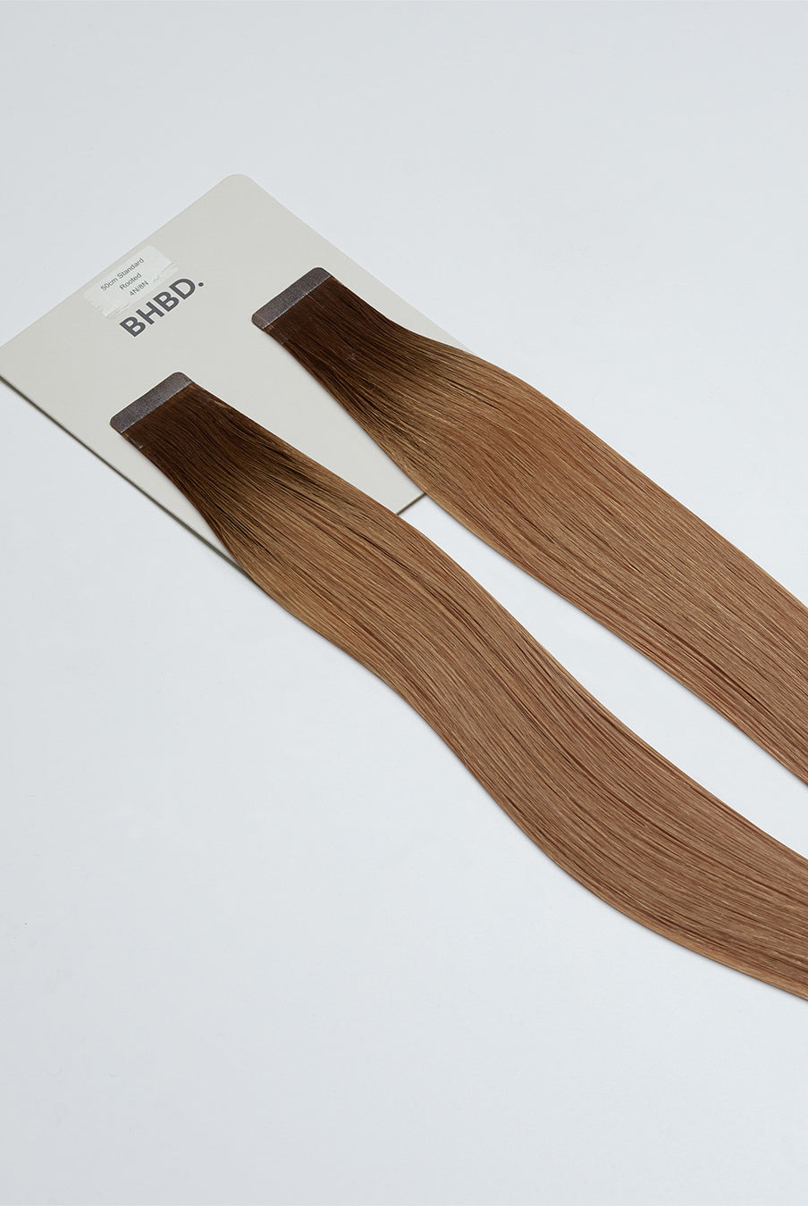 Tape Extensions 4N/8N – pre-taped Remy human hair extensions in dark brown blended with medium natural blonde; seamless, soft and tangle-free; comes in 35cm, 50cm, and 60cm. 100% Remy hair, gentle extensions.