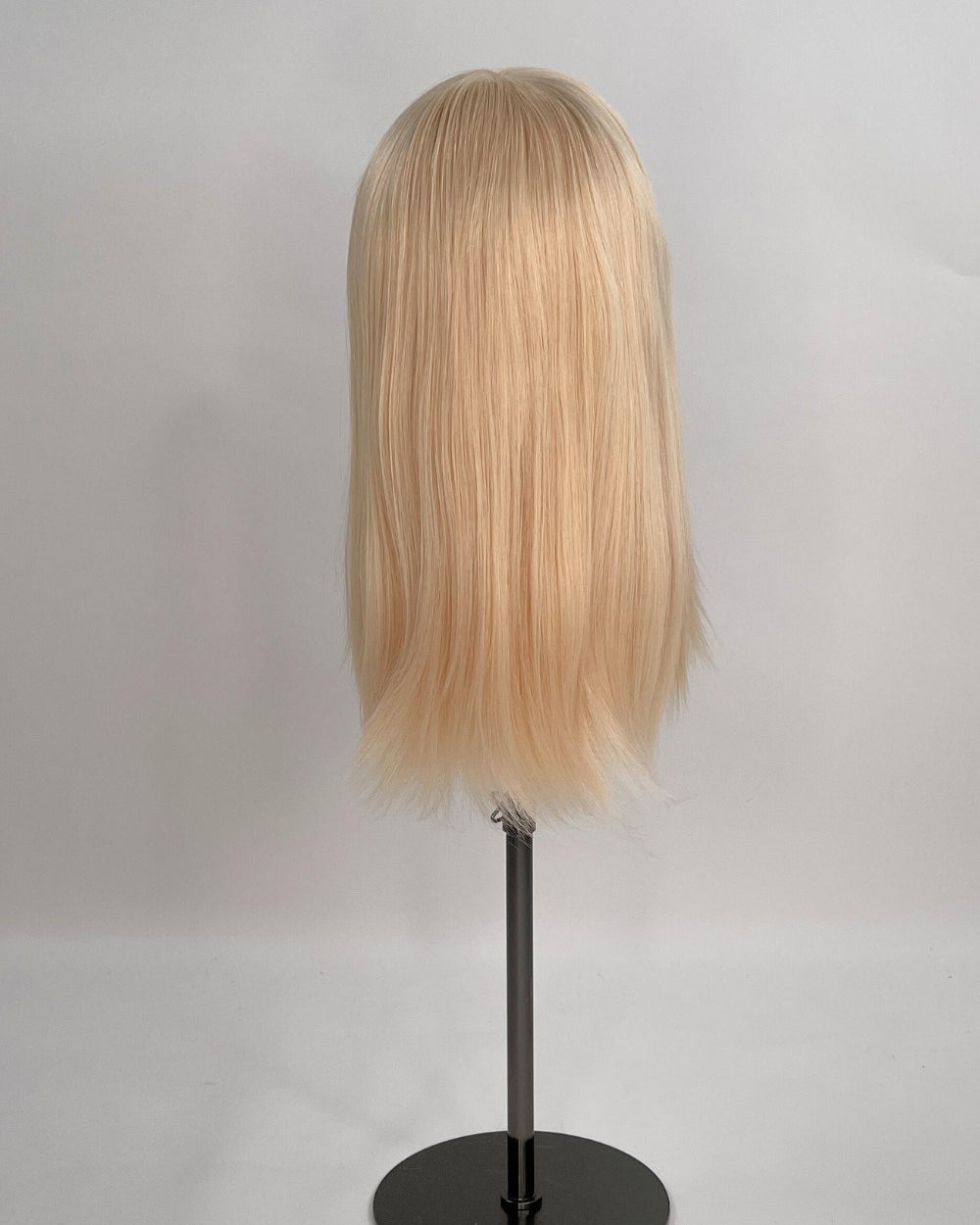 Bianca Wig – light blonde, 30cm full-lace wig; 100% Remy hair with transparent Swiss lace and natural density on a wig stand from the back.