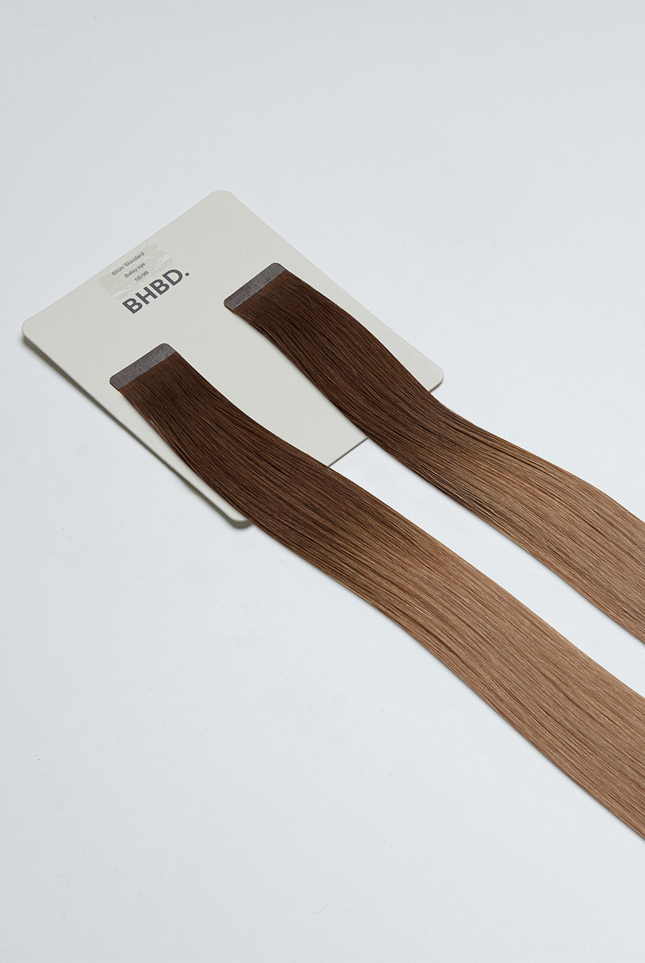 Tape Extensions 5B/9B – pre-taped Remy human hair extensions in medium brown blended with light beige blonde; seamless, soft and tangle-free; comes in 35cm, 50cm, and 60cm. 100% Remy hair, gentle extensions.
