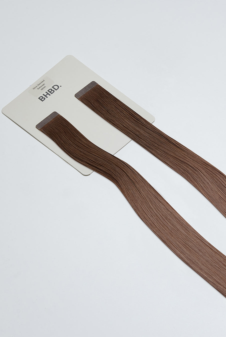 Tape Extensions 6B/9A – pre-taped Remy human hair extensions in medium brown and light ash blonde blend; seamless, soft and tangle-free; comes in 35cm, 50cm, and 60cm. 100% Remy hair, gentle extensions.