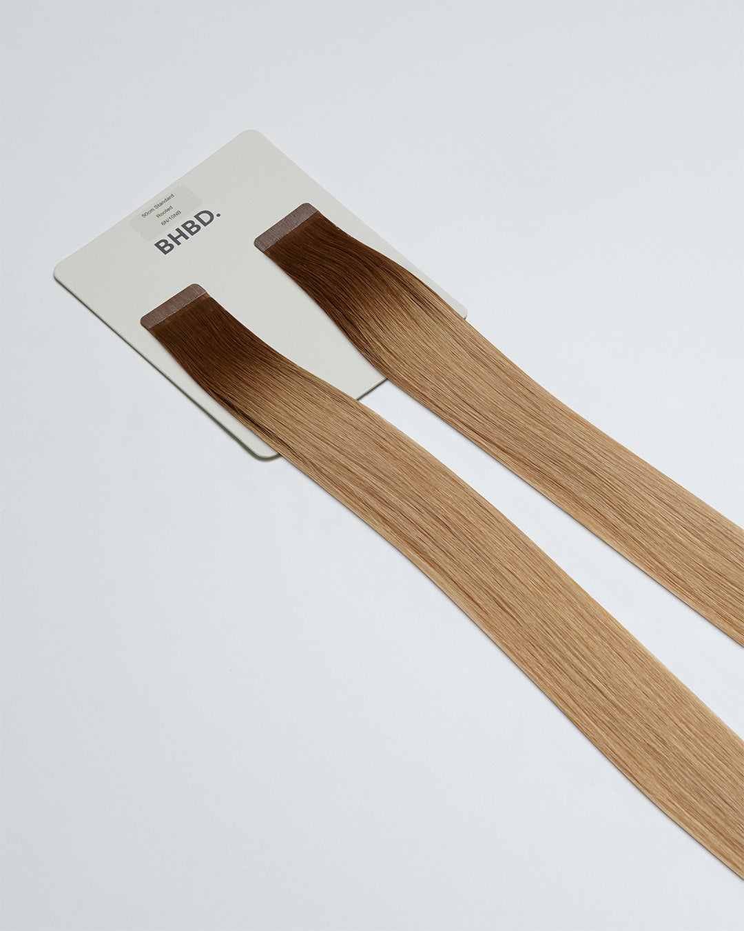 Tape Extensions 6N/10NB – pre-taped Remy human hair extensions in natural brown blended with light beige blonde; seamless, soft and tangle-free; comes in 35cm, 50cm, and 60cm. 100% Remy hair, gentle extensions.