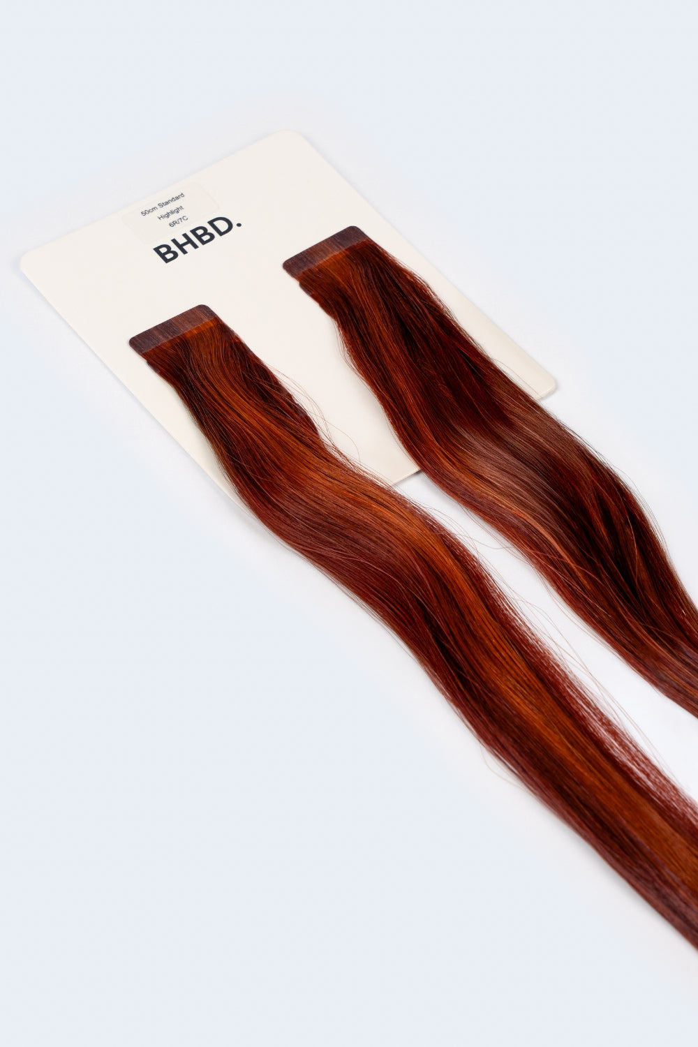 BHBD Tape Extensions 6R/7C – pre-taped Remy human hair extensions in warm copper and auburn tones; seamless, soft and tangle-free; comes in 35cm, 50cm, and 60cm. 100% Remy hair, gentle extensions.