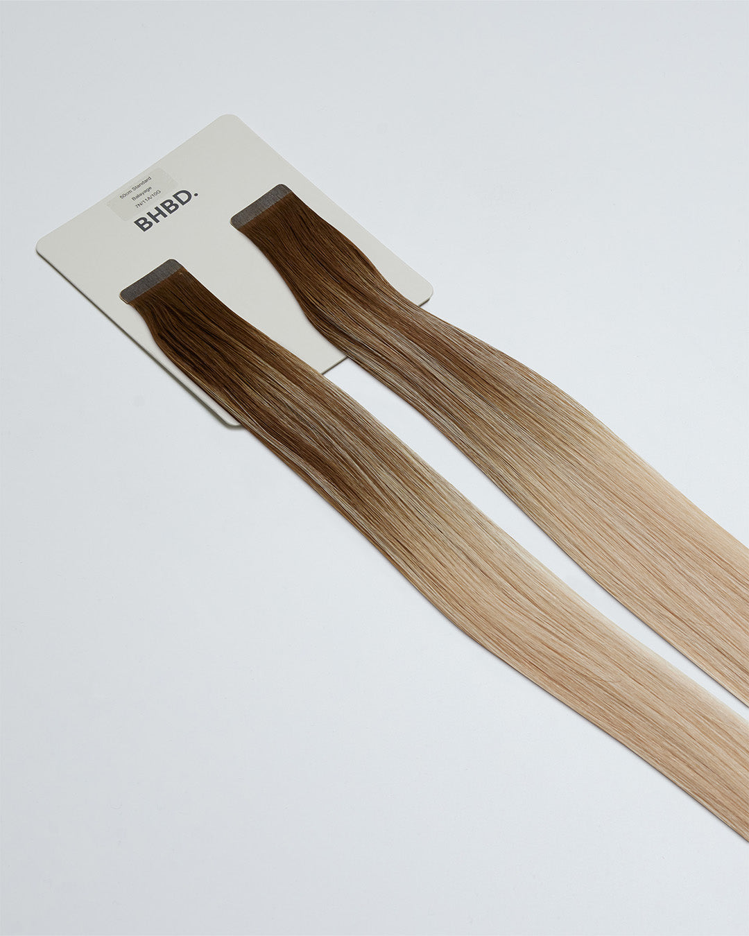 Tape Extensions 7N/11A/10G – pre-taped Remy human hair extensions in medium natural blonde, light ash blonde, and golden blonde blend; seamless, soft and tangle-free; comes in 35cm, 50cm, and 60cm. 100% Remy hair, gentle extensions.