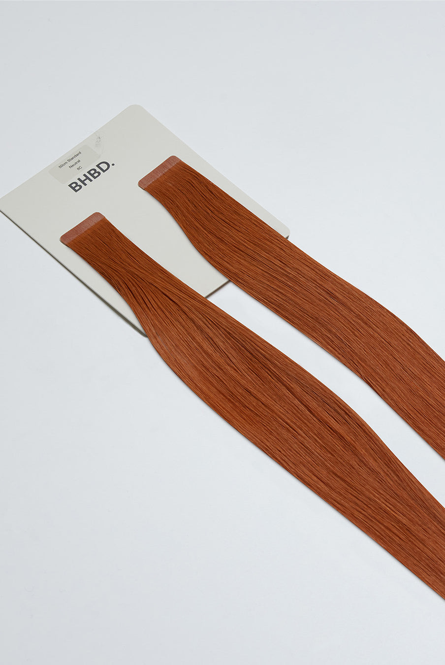 Tape Extensions 8C – pre-taped Remy human hair extensions in warm copper blonde shade; seamless, soft and tangle-free; comes in 35cm, 50cm, and 60cm. 100% Remy hair, gentle extensions.
