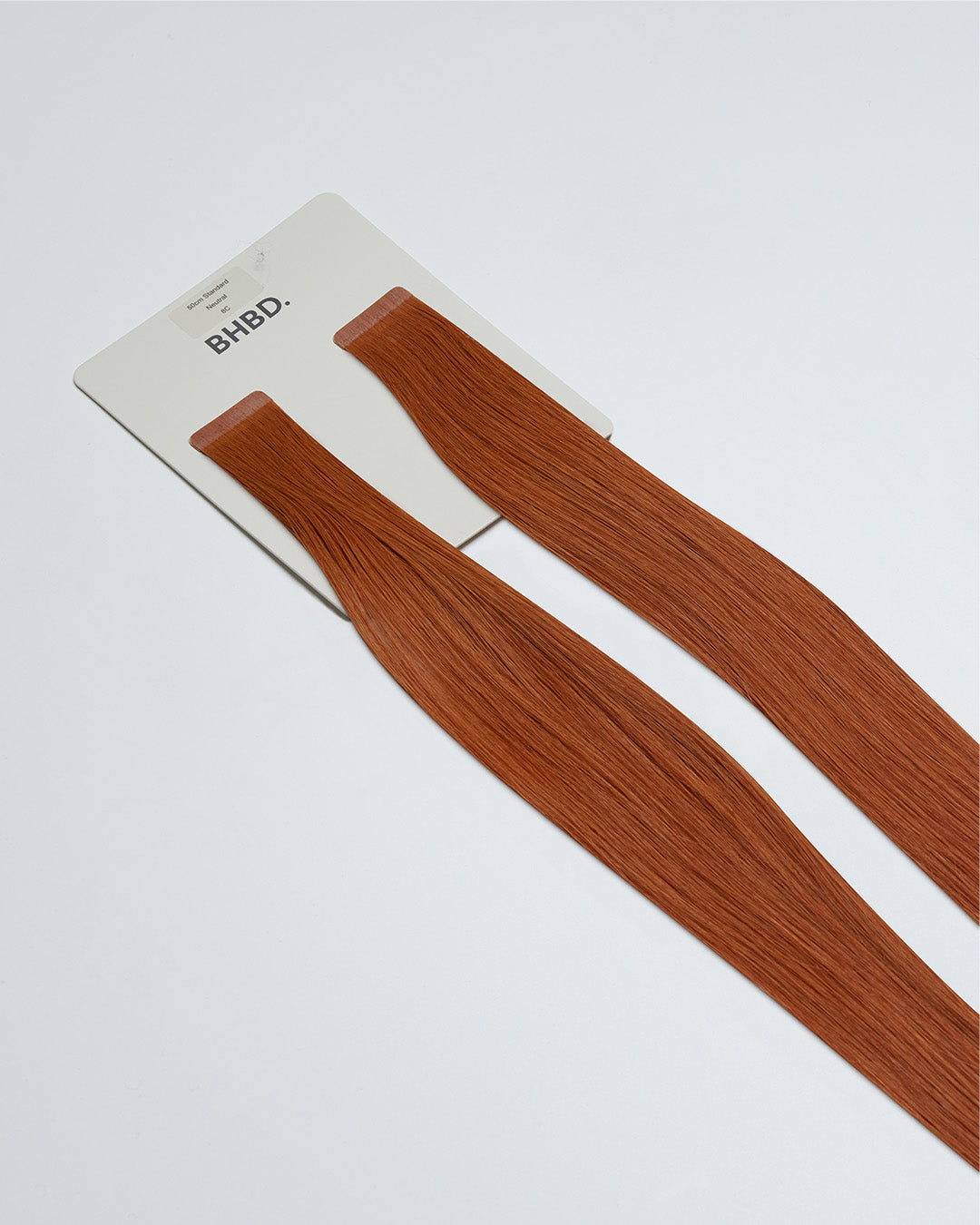 Tape Extensions 8C – pre-taped Remy human hair extensions in warm copper blonde shade; seamless, soft and tangle-free; comes in 35cm, 50cm, and 60cm. 100% Remy hair, gentle extensions.