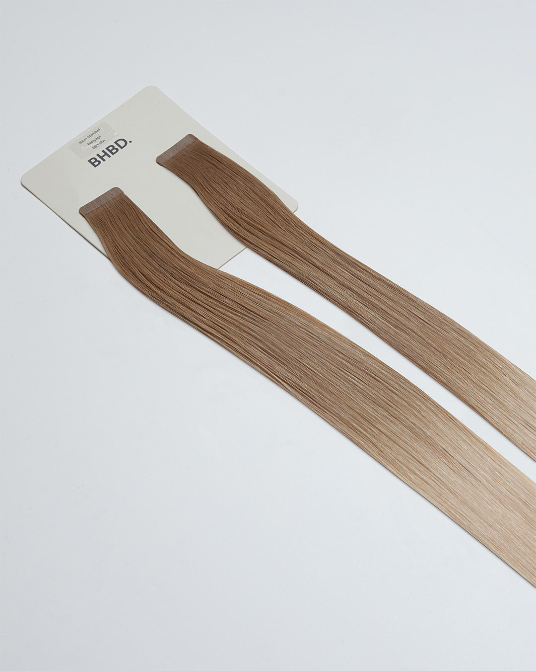 Tape Extensions 9B/11BA – pre-taped Remy human hair extensions in light beige blonde and ash blonde mix; seamless, soft and tangle-free; comes in 35cm, 50cm, and 60cm. 100% Remy hair, gentle extensions.