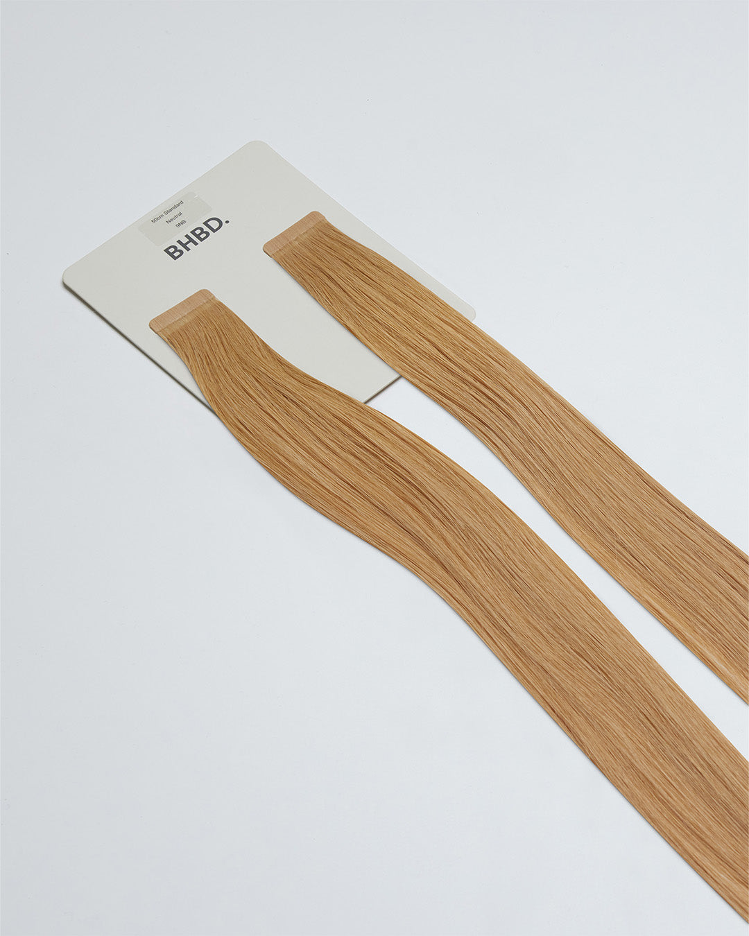 Tape Extensions 9NB – pre-taped Remy human hair extensions in natural beige blonde shade; seamless, soft and tangle-free; comes in 35cm, 50cm, and 60cm. 100% Remy hair, gentle extensions.