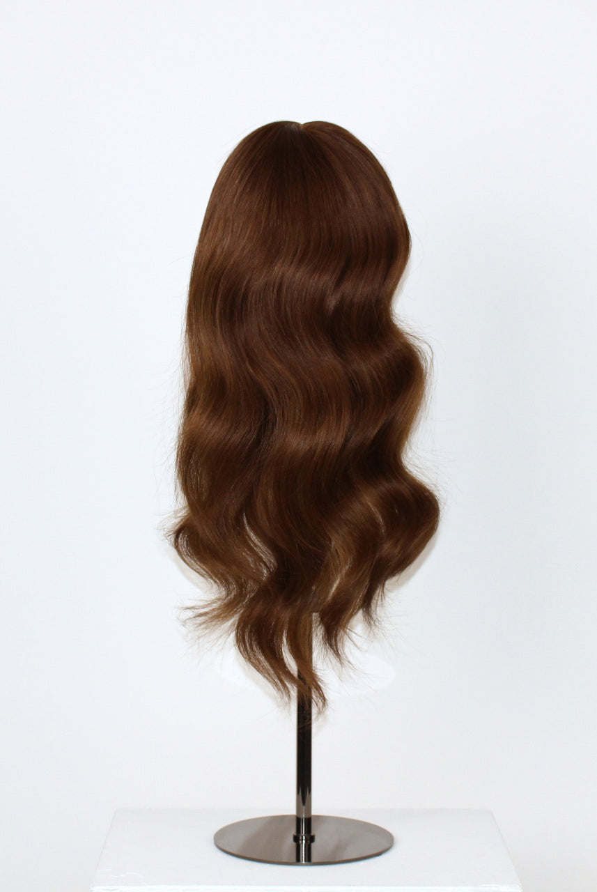 Daisy Wig 40 cm Remy human hair wig with natural brown blend and cropped layered lengths for soft movement, displayed on stand. Back view