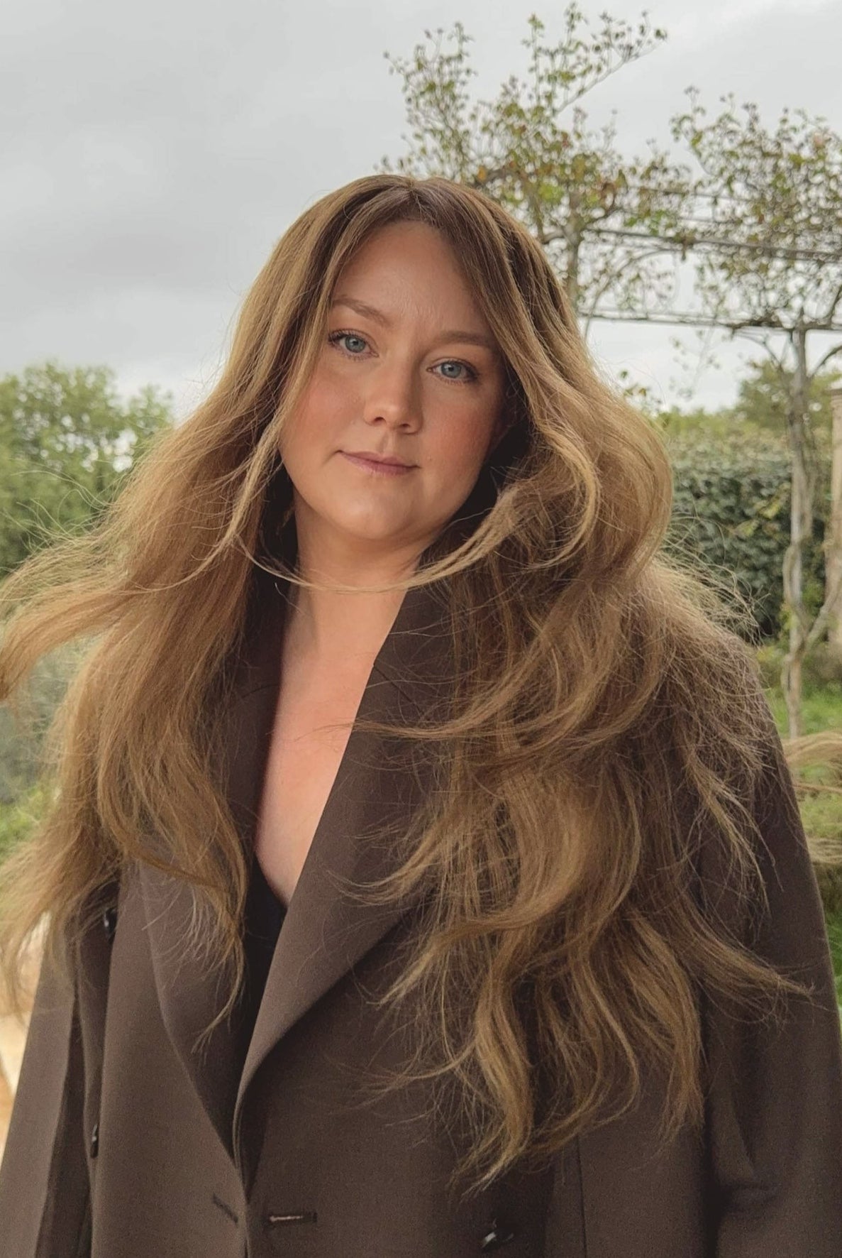 Woman wearing a long BHBD Elena wig with blended balayage, soft caramel brown tones and cool medium brown lengths.