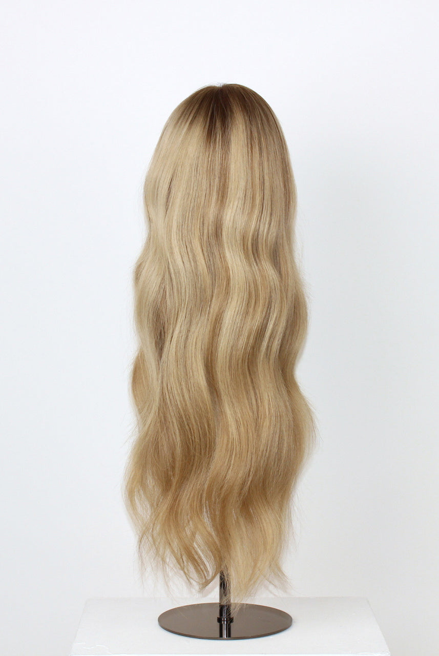 Scarlet Wig 50 cm blonde Remy human hair wig with soft lowlights and darker root for depth and texture, displayed on stand.