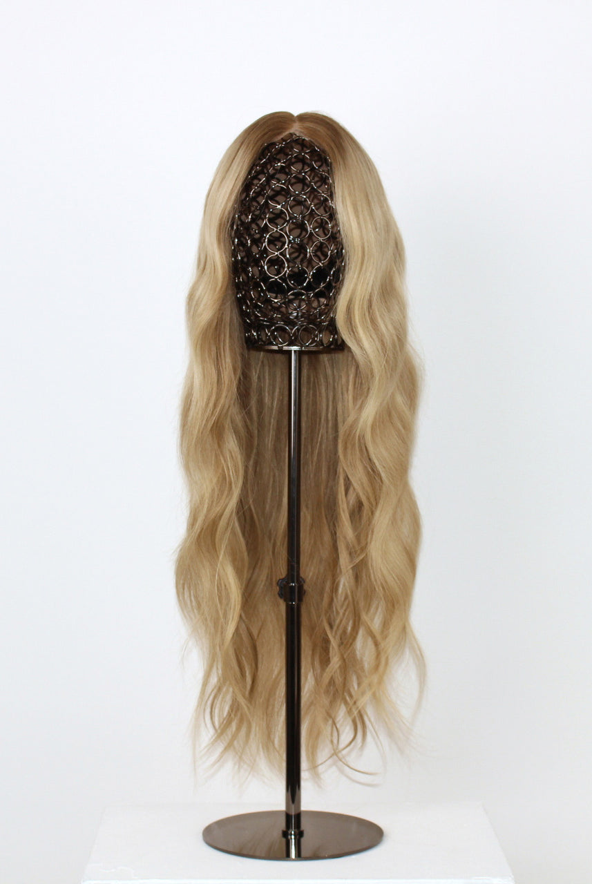 Scarlet Wig 50 cm natural blonde human hair wig with dark root and fine lowlights for dimension, hand-tied on HD lace front, displayed on stand. Front view