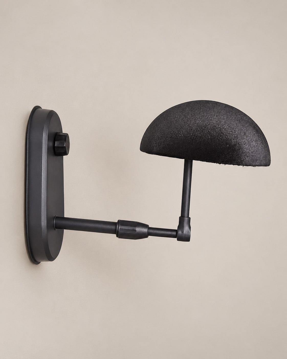 Black wall-mounted travel wig stand with a curved arm.