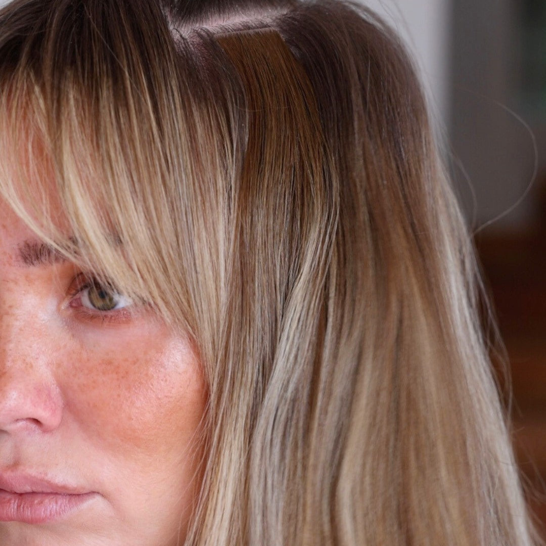 Close-up of a woman with brown hair and BHBD tape hair extensions.