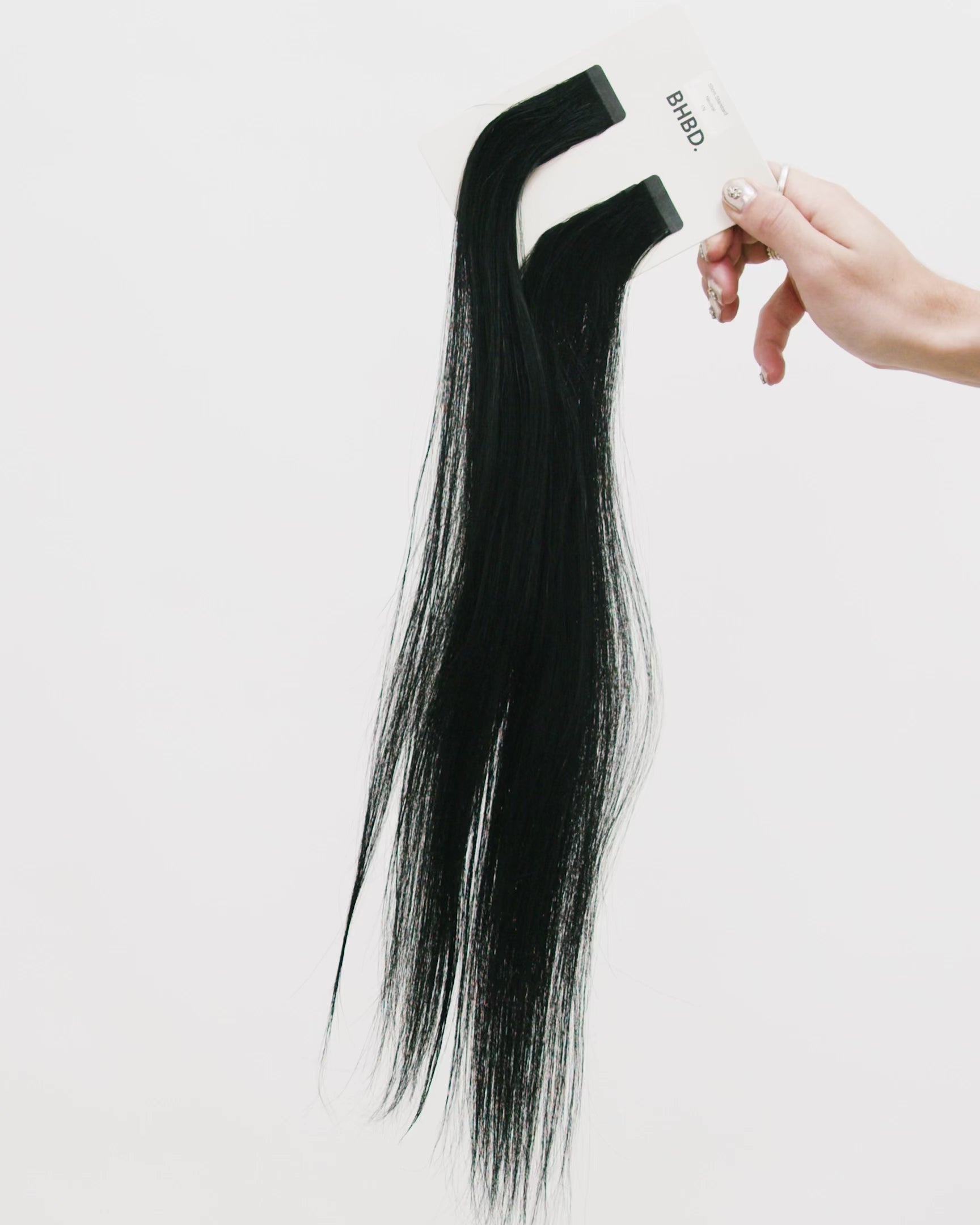 Tape Extensions 1N – pre-taped Remy human hair extensions in natural black shade; seamless, soft and tangle-free; comes in 35cm, 50cm, and 60cm. 100% Remy hair, gentle extensions.