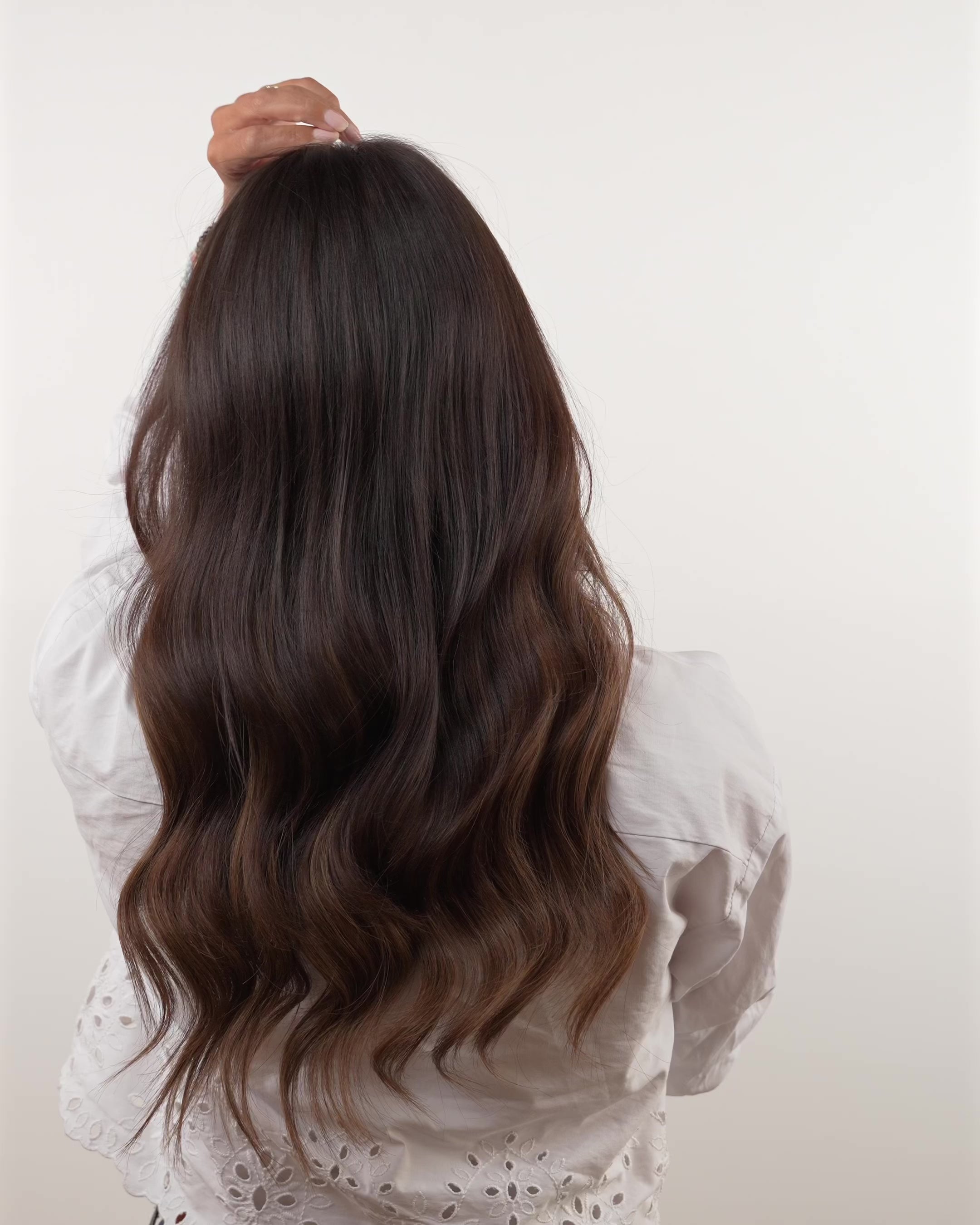 Woman with brown hair removing a BHBD hairband showing how the hair looks from the back with BHBD hairband hair extensions and without.