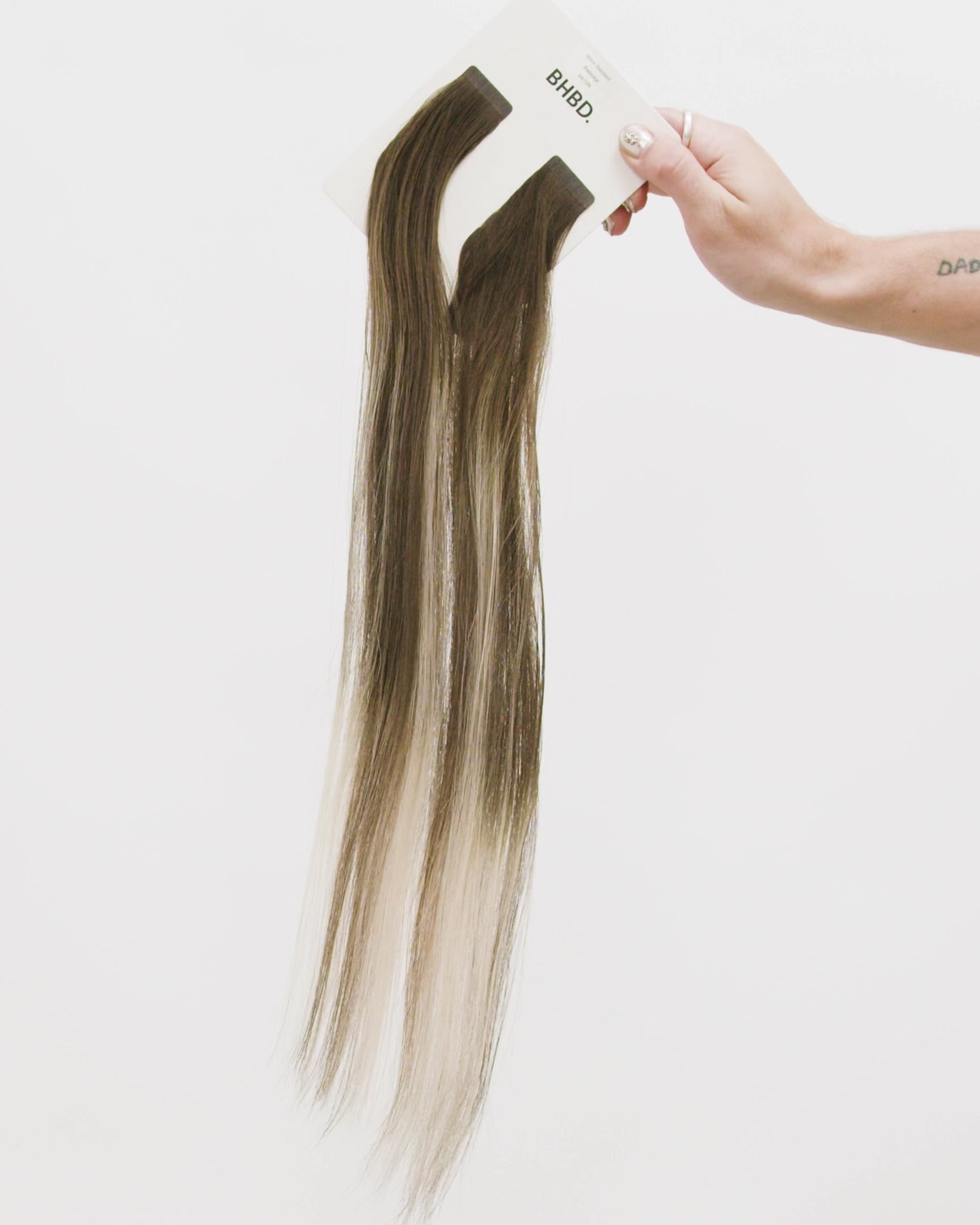 Tape Extensions 6A/12N – pre-taped Remy human hair extensions in medium ash brown blended with light natural blonde; seamless, soft and tangle-free; comes in 35cm, 50cm, and 60cm. 100% Remy hair, gentle extensions.