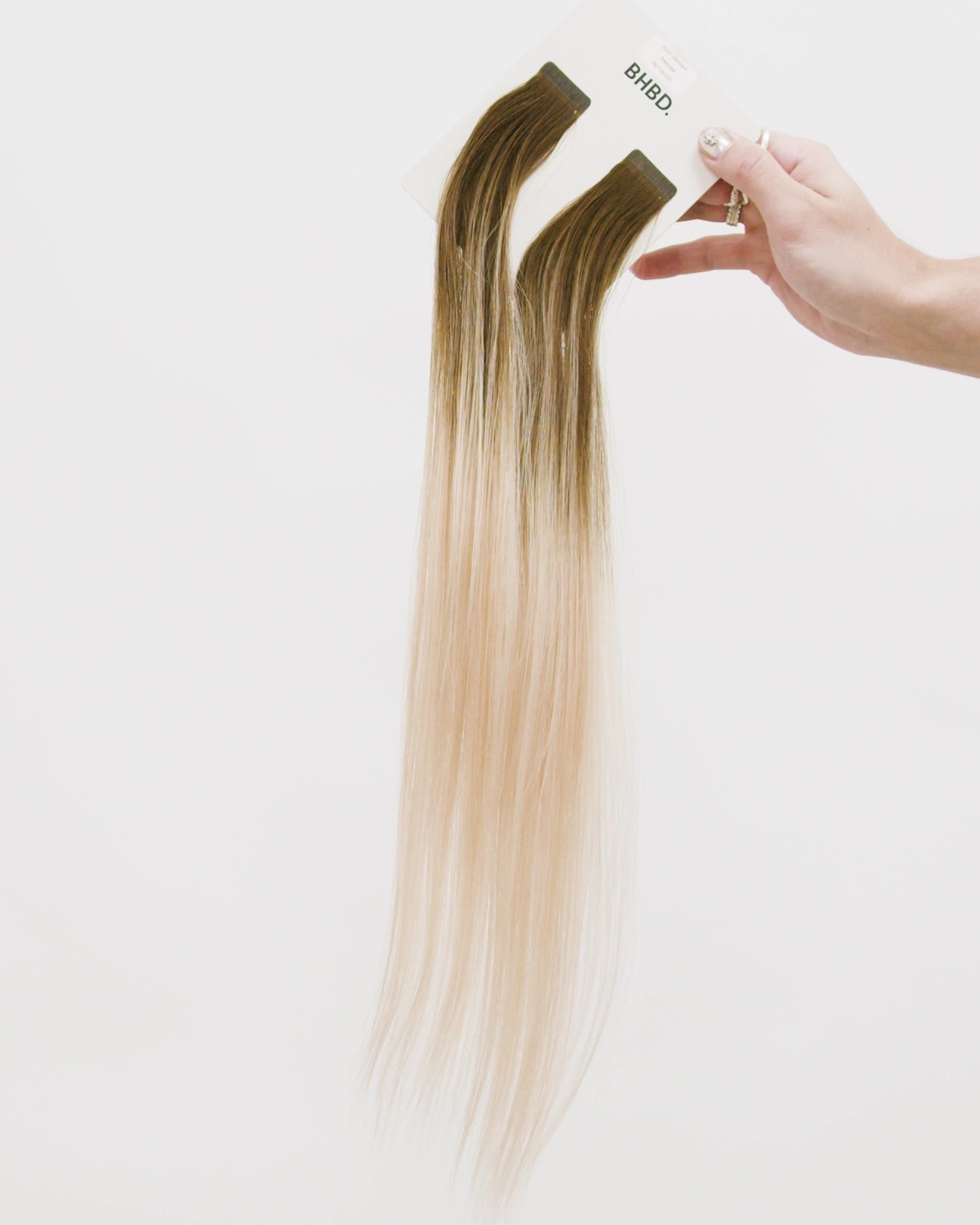 Tape Extensions 7N/11A/10G – pre-taped Remy human hair extensions in medium natural blonde, light ash blonde, and golden blonde blend; seamless, soft and tangle-free; comes in 35cm, 50cm, and 60cm. 100% Remy hair, gentle extensions.