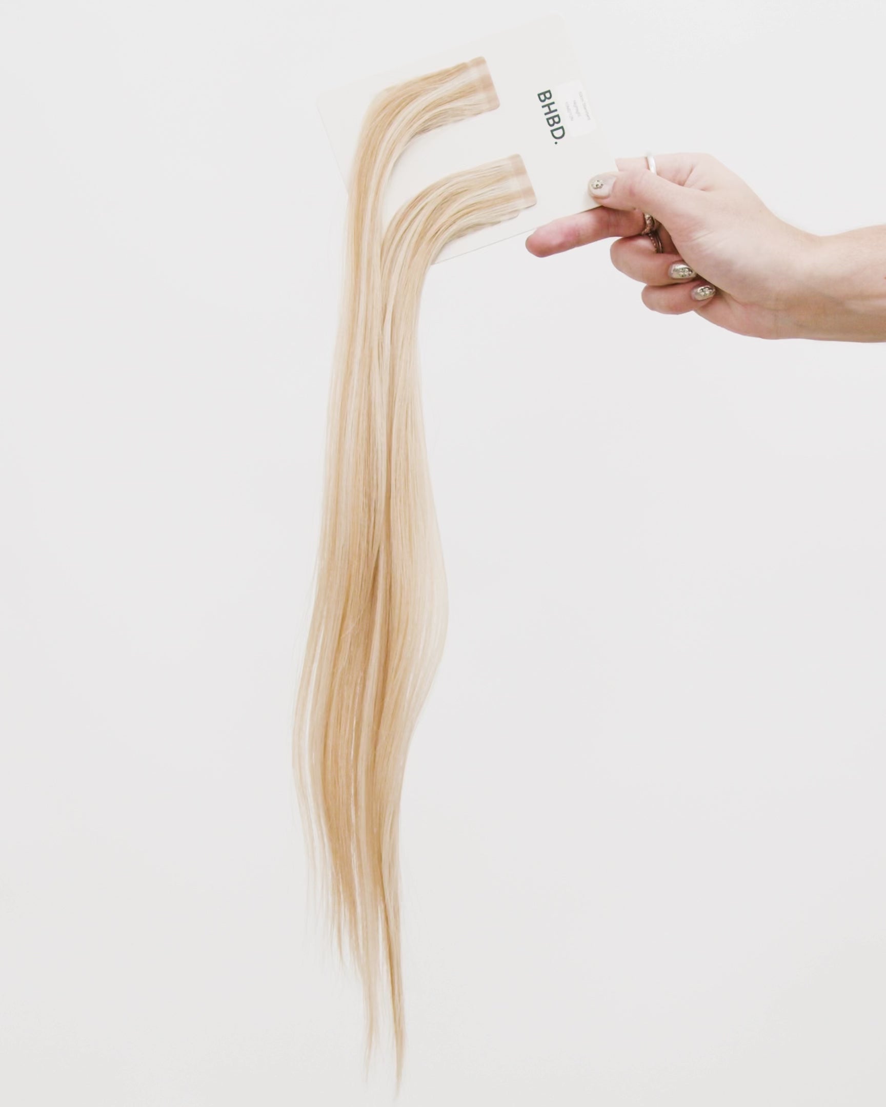 Tape Extensions 10NB/12N – pre-taped Remy human hair extensions in light beige blonde blended with natural blonde; seamless, soft and tangle-free; comes in 35cm, 50cm, and 60cm. 100% Remy hair, gentle extensions