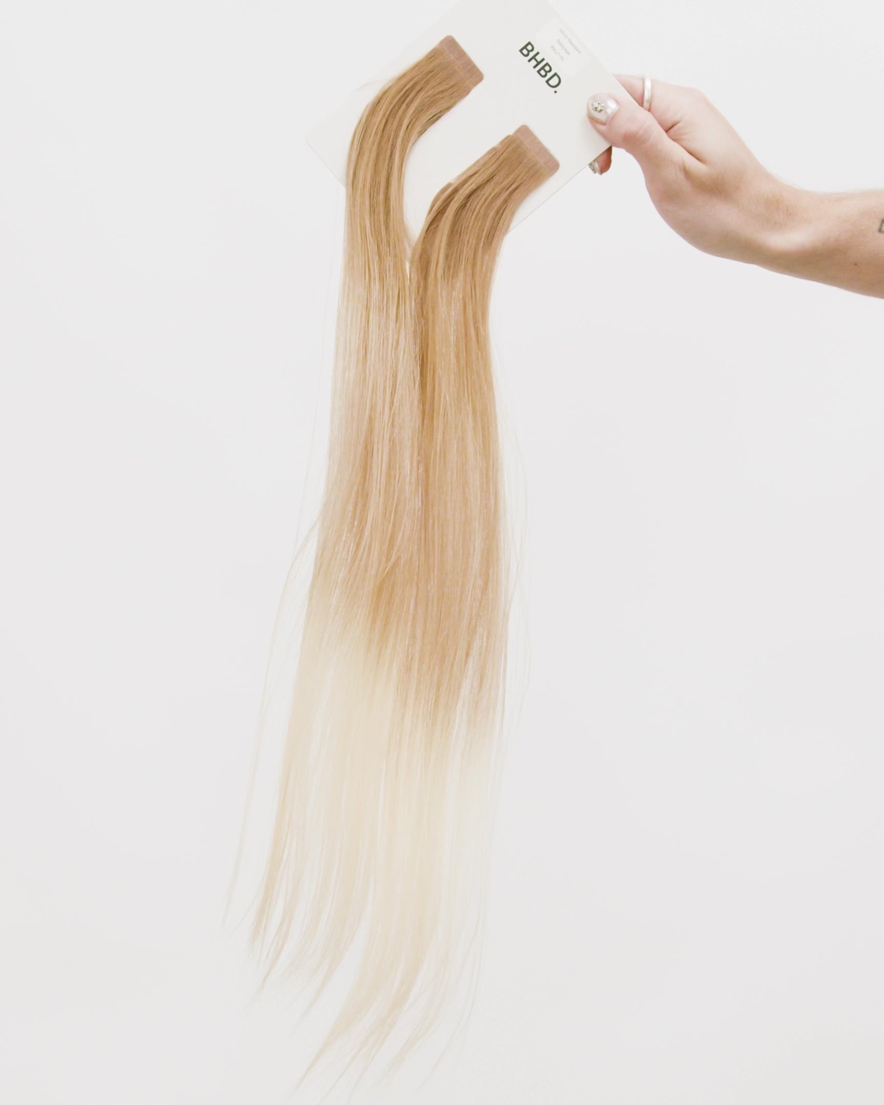 Tape Extensions 9NG/11N – pre-taped Remy human hair extensions in golden natural blonde blended with medium natural blonde; seamless, soft and tangle-free; comes in 35cm, 50cm, and 60cm. 100% Remy hair, gentle extensions.