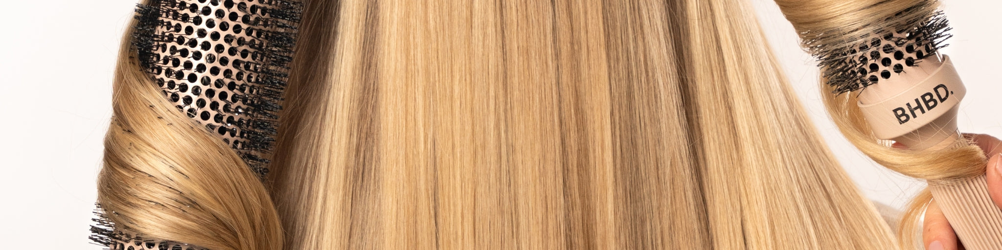 Close-up of BHBD round brushes styling sleek blonde hair, showcasing the smooth, professional finish achieved with ceramic and ionic technology.