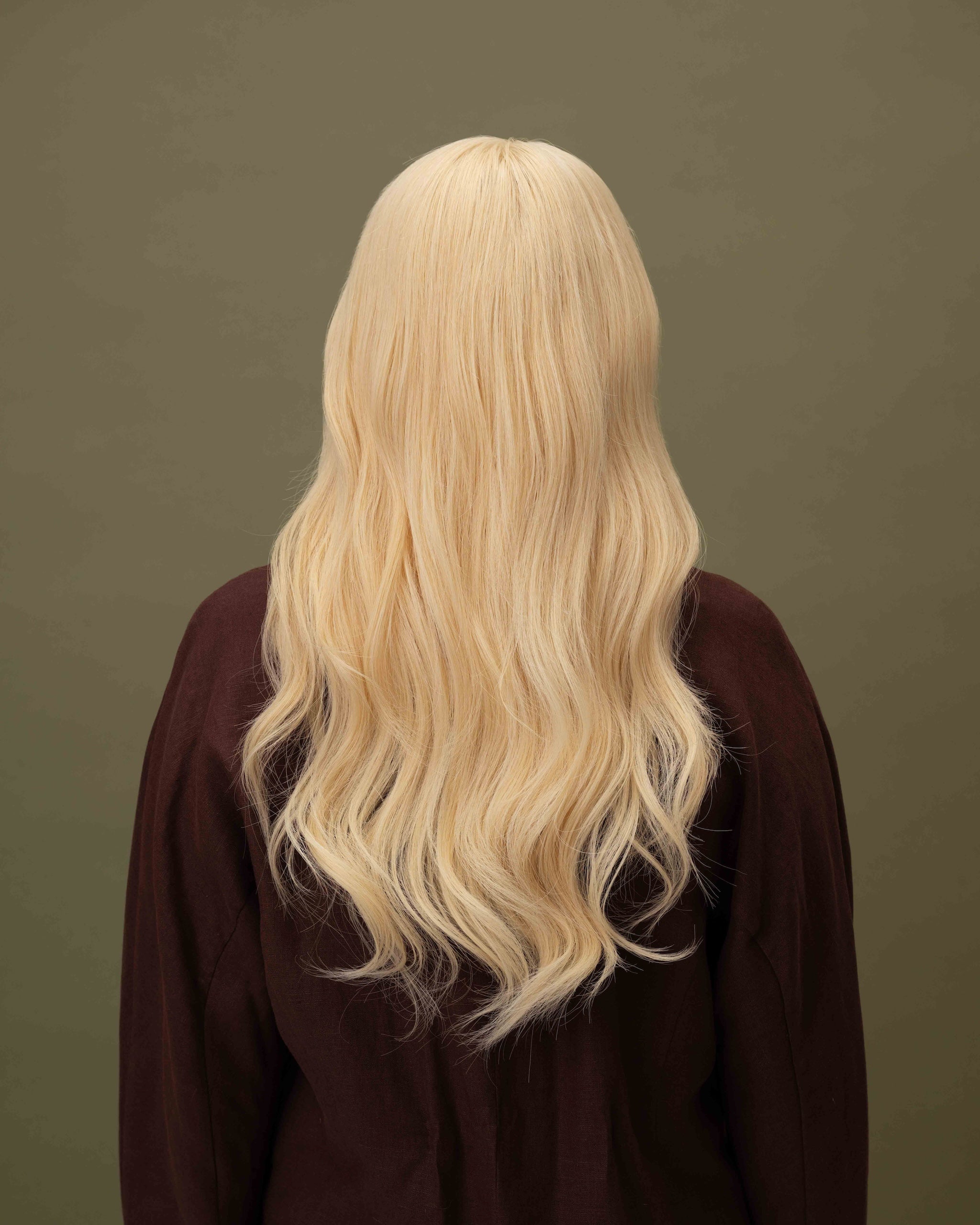 Back view on model wearing Livia Wig – 40cm warm blonde Remy hair wig shown from the back; full lace with layered lengths.