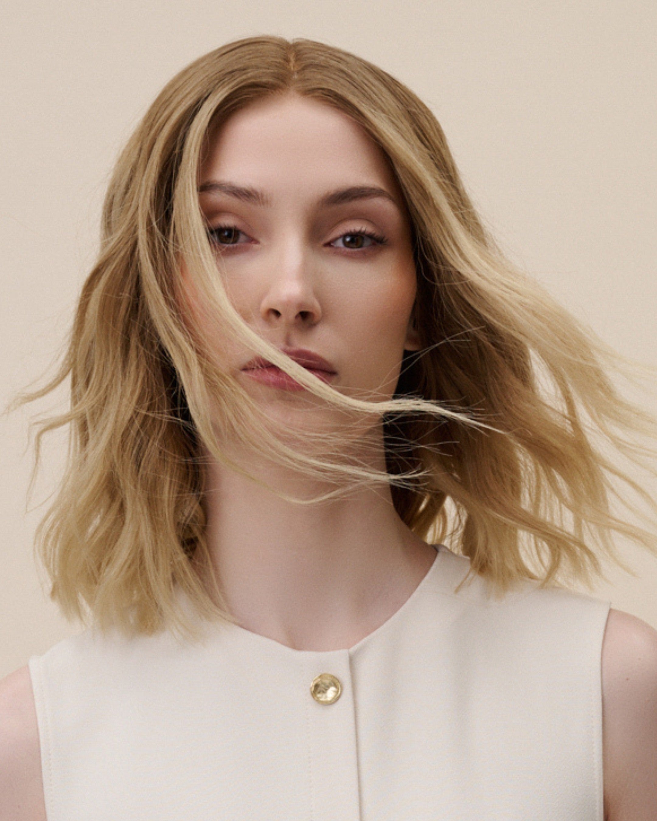 Statice Wig 30 cm human hair wig with darker root and golden blonde tones, hand-tied on HD lace front for realistic scalp effect, displayed on stand.