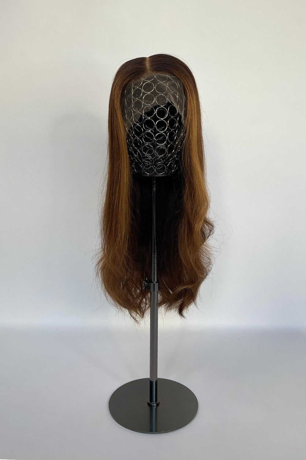 Premium BHBD half & full lace wig in a warm brown shade with soft, flowing waves, displayed on a mannequin stand. Made with 100% real Remy hair, offering a natural parting and seamless, elegant look.