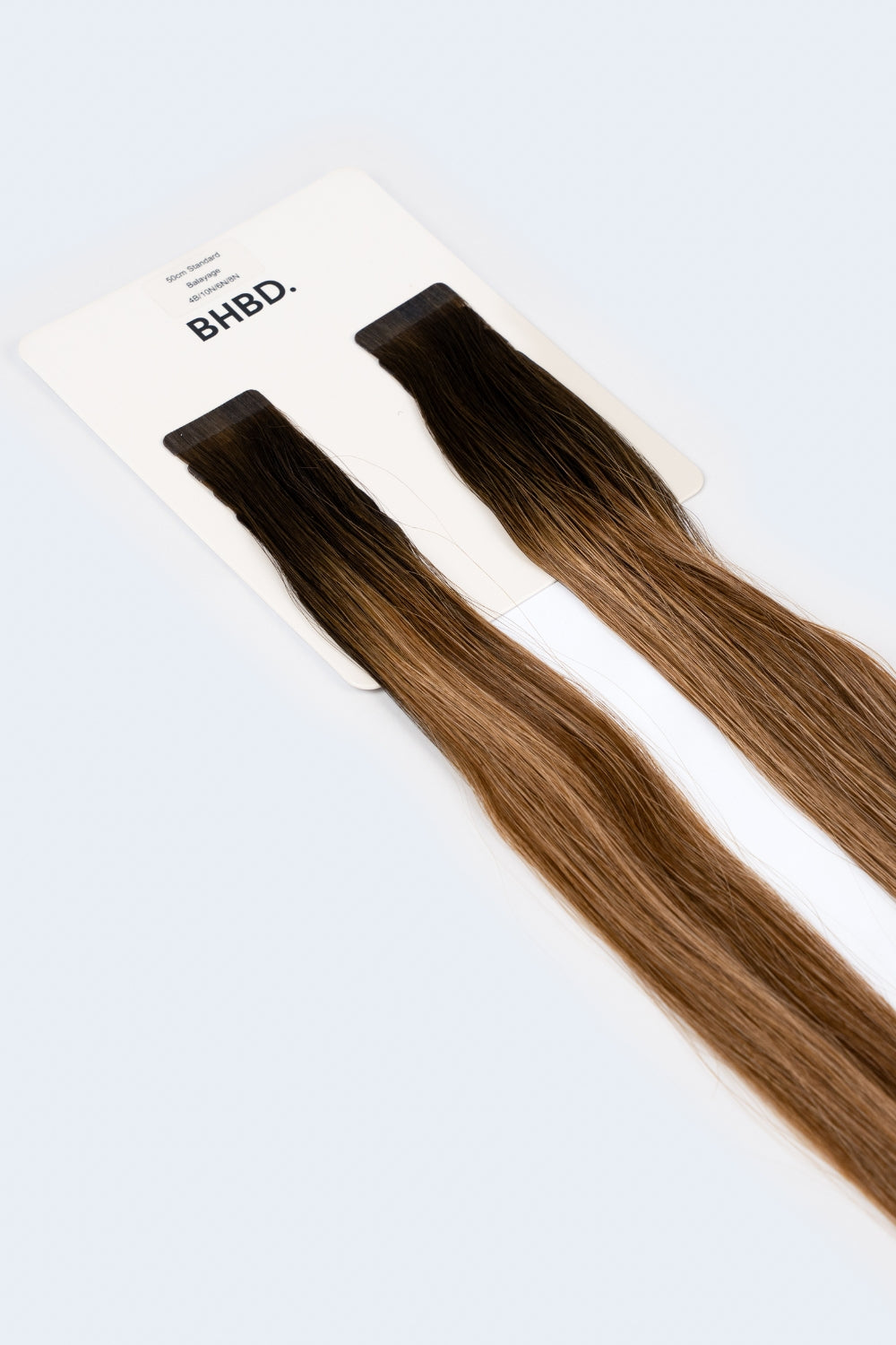 BHBD Tape Extensions 4B/10N/6N/8N – pre-taped Remy human hair extensions in mixed brunette and blonde shades; seamless, soft and tangle-free; comes in 35cm, 50cm, and 60cm. 100% Remy hair, gentle extensions.