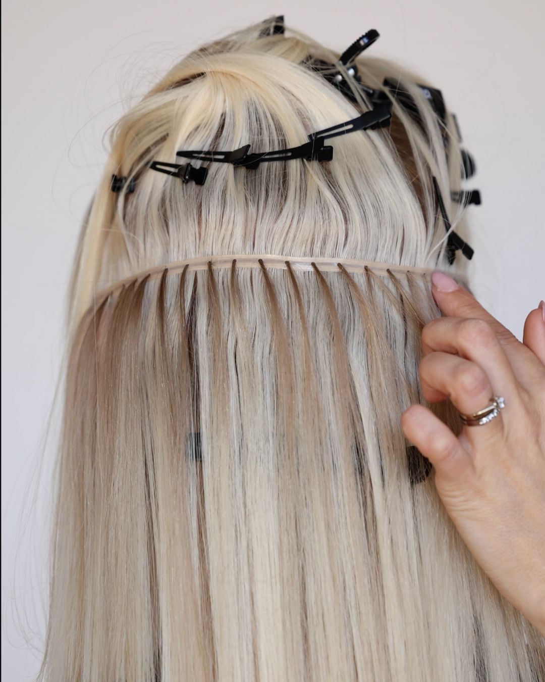 BHBD Weft extensions being applied with clips holding natural hair in place. 100% Remy hair, gentle extensions.