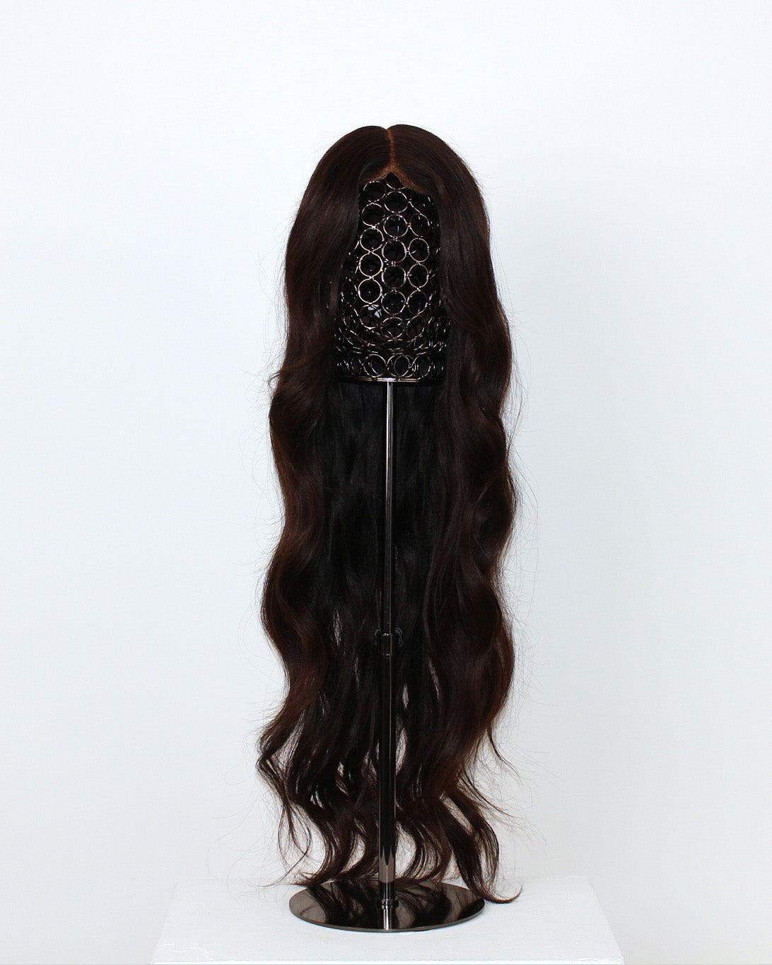 Aurora Wavy Wig 65 cm – dark brown Remy human hair with soft beach waves on HD lace, displayed on a wig stand against a white background