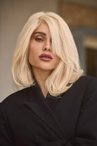 Woman wearing a BHBD Bianca platinum blonde wig in a cool blonde shade.