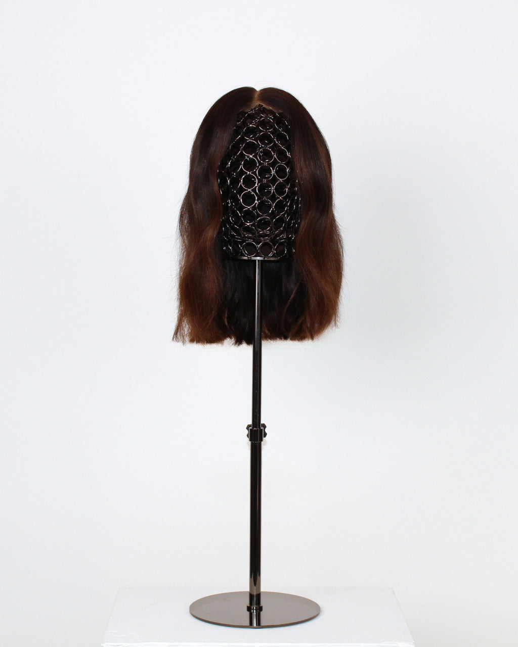 Celosia Wig 30 cm human-hair wig with dark to light brown blend and HD-lace front for realistic scalp effect, displayed on stand. front view
