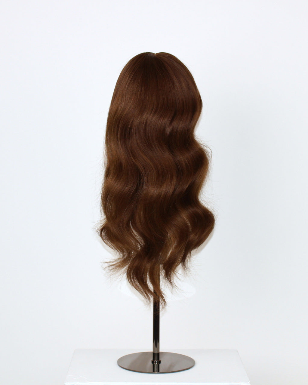 Daisy Wig 40 cm Remy human hair wig with natural brown blend and cropped layered lengths for soft movement, displayed on stand. Back view