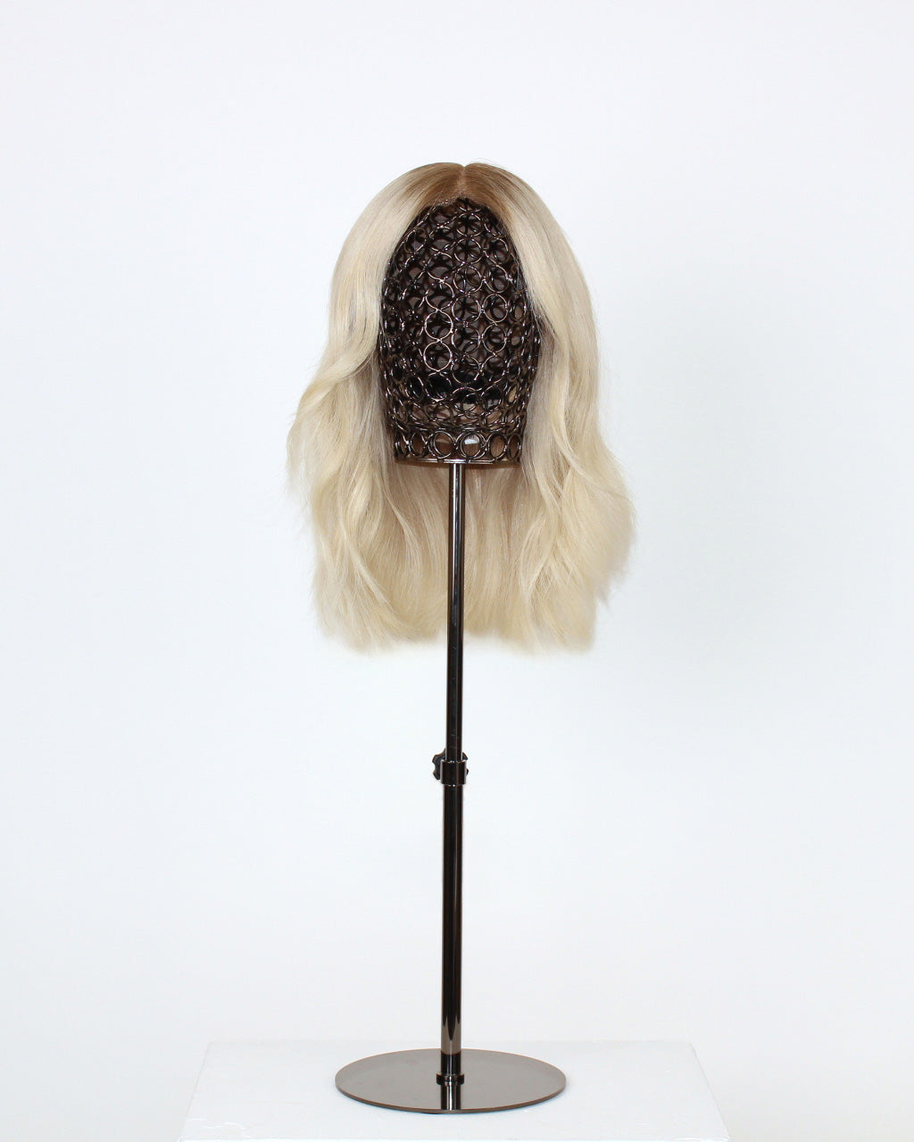 Fiorella Wig 35 cm hand-tied platinum ash blonde human hair wig with cool dark blonde root, displayed on stand with HD lace front. Front view