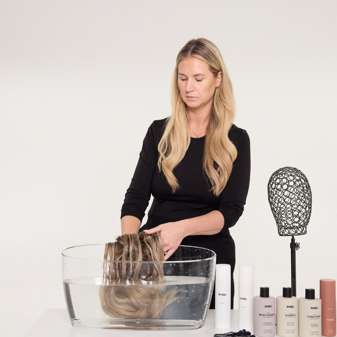 Woman washing a wig in a bowl with BHBD deep conditioner