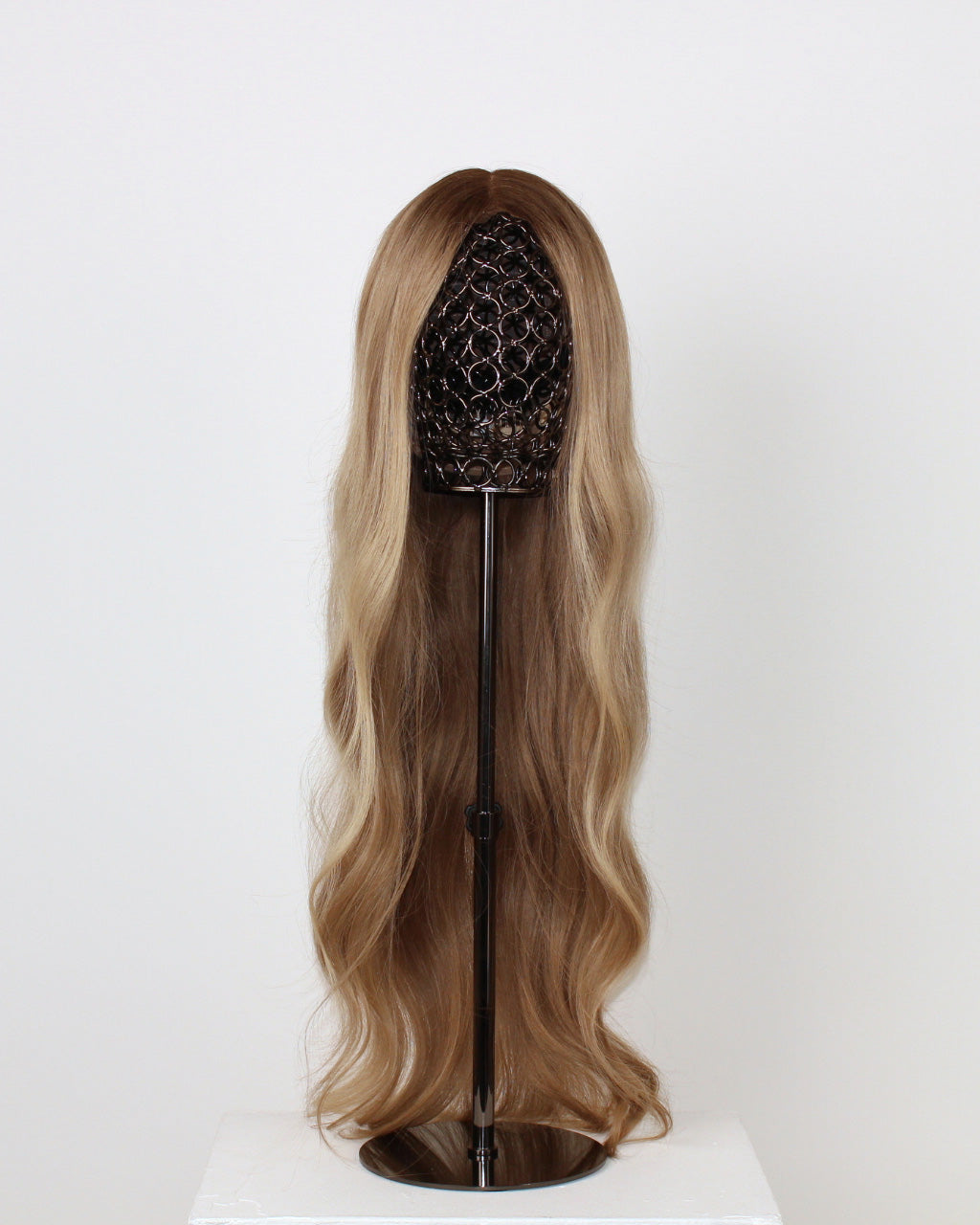 BHBD Lana Wig 65 cm – cool caramel blonde human hair wig with darker roots and softly layered 65 cm length displayed on a wig stand against a white background
