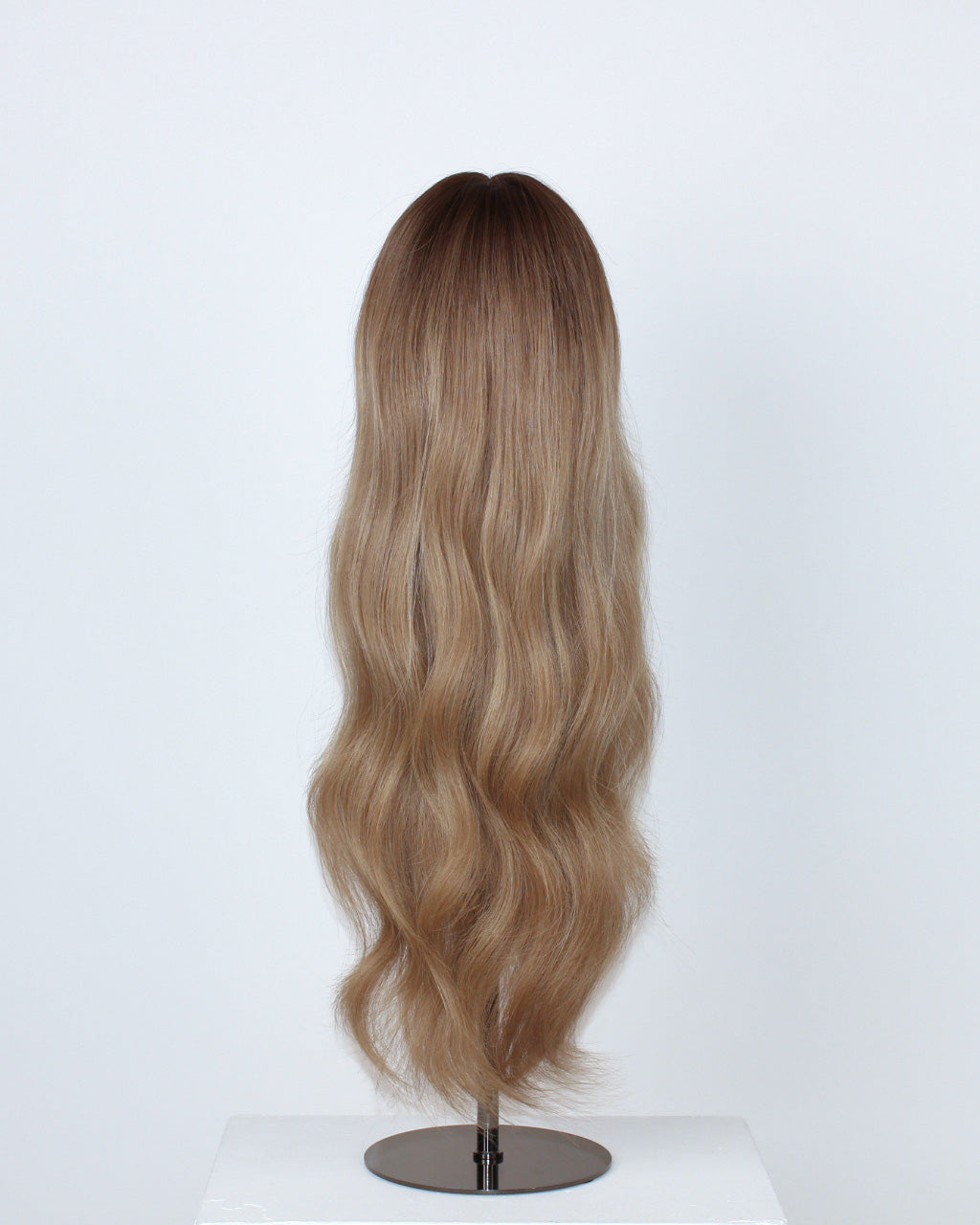 Back view of Noble Nightshade Wig 50 cm Remy human hair with dark blonde root and lighter front highlights, hand-tied on HD lace, displayed on mannequin wig stand.