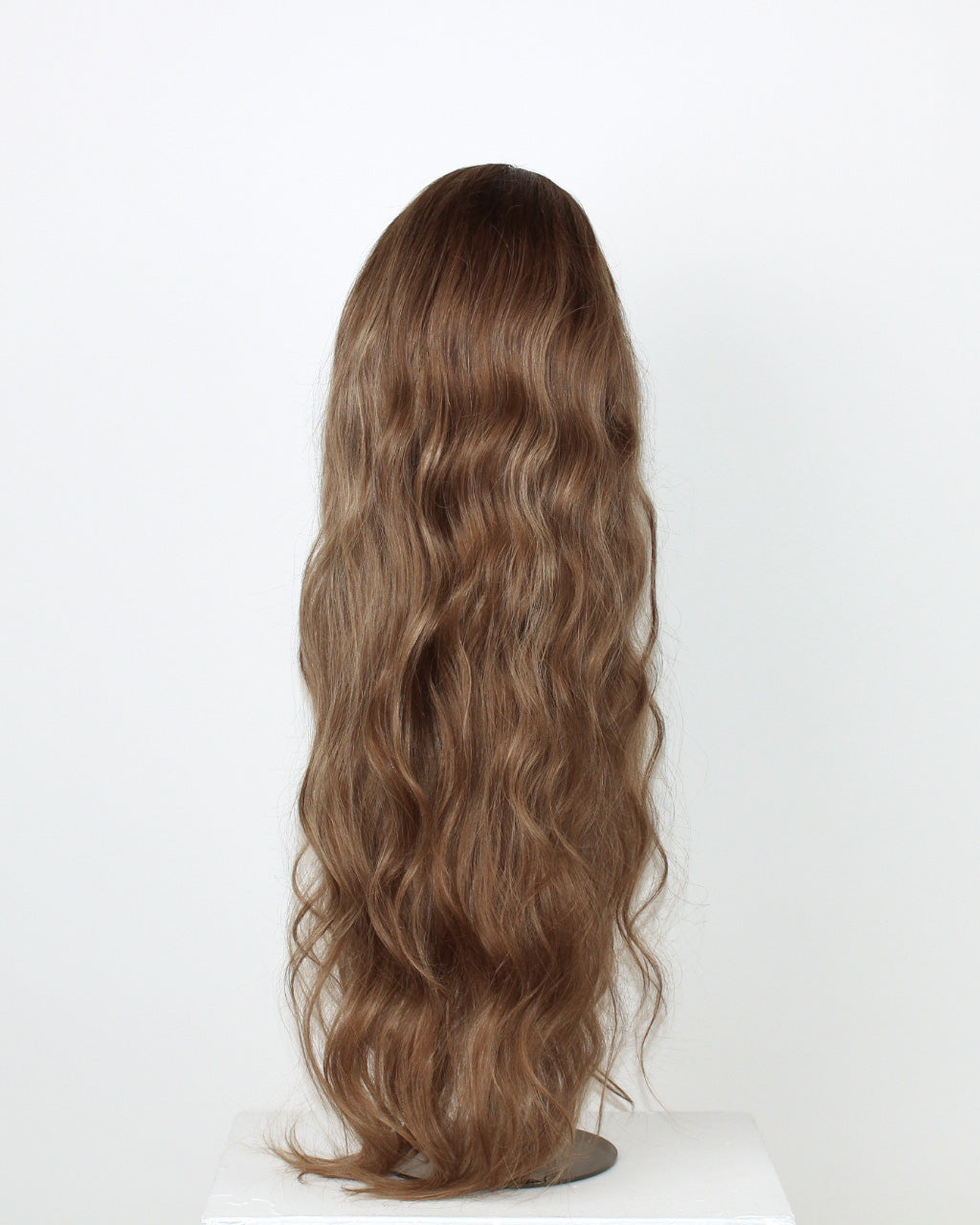 Back view of Noble Nightshade Wig 65 cm – dark blonde Remy human hair wig with softly layered waves shown on a stand against a white background