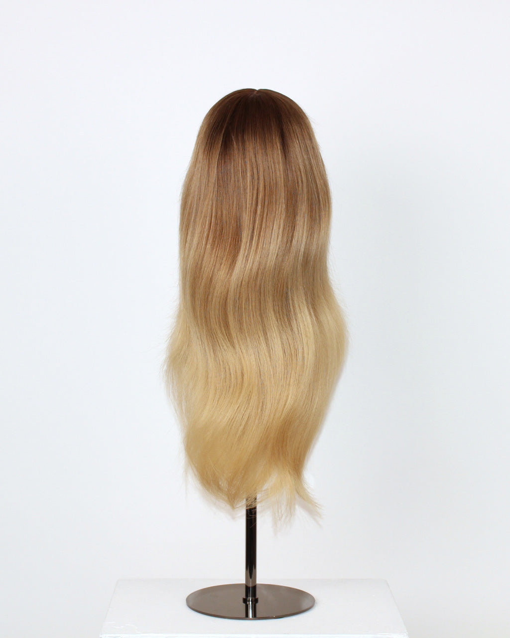 Statice Wig 40 cm real human hair in medium blonde with subtle golden tones, hand-tied on HD lace, displayed from the back on a wig stand to show natural color blend and shine.