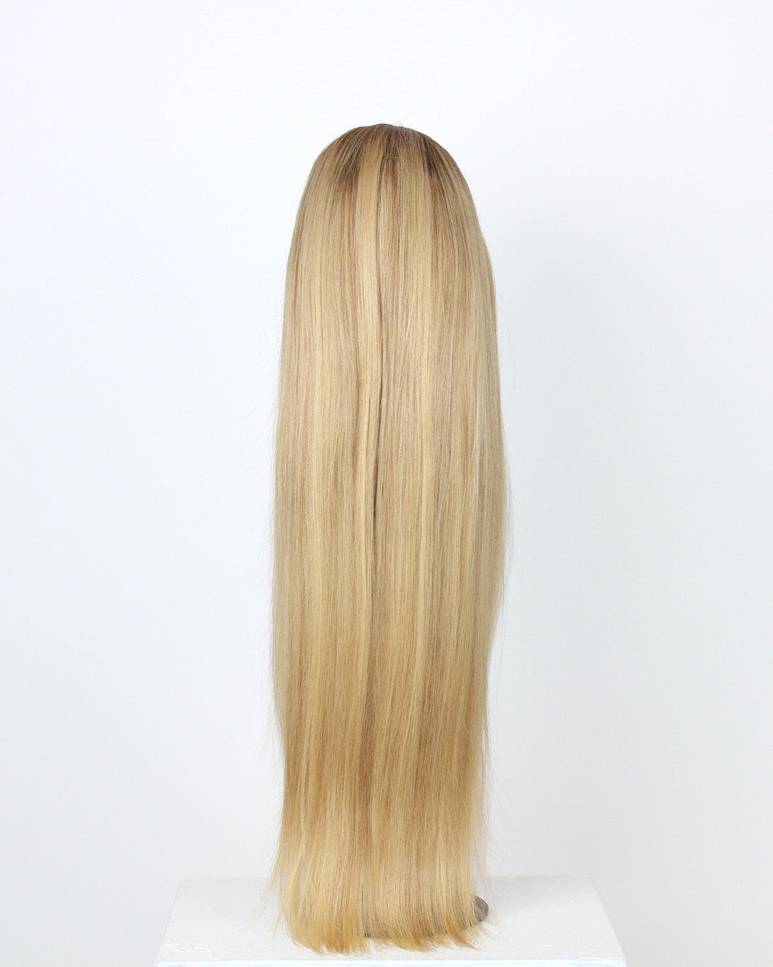 Vera Wig / 65cm – 65 cm light blonde Remy human hair wig with darker roots, straight and glossy, shown on a mannequin head from the back against a neutral background.