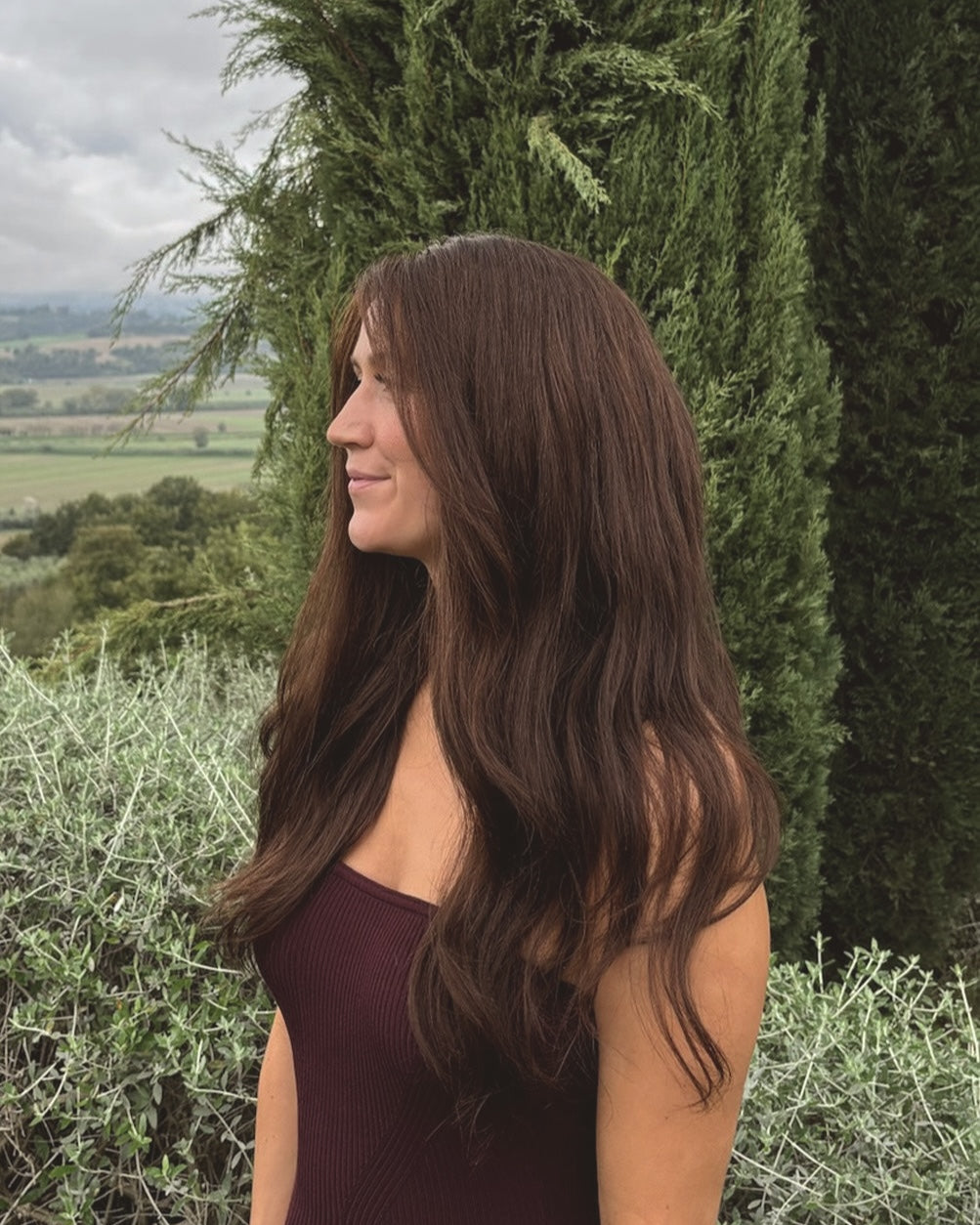 Valentina Wig – 40cm dark brown lace wig worn outdoors on woman; natural Remy hair styled with soft, glossy waves.