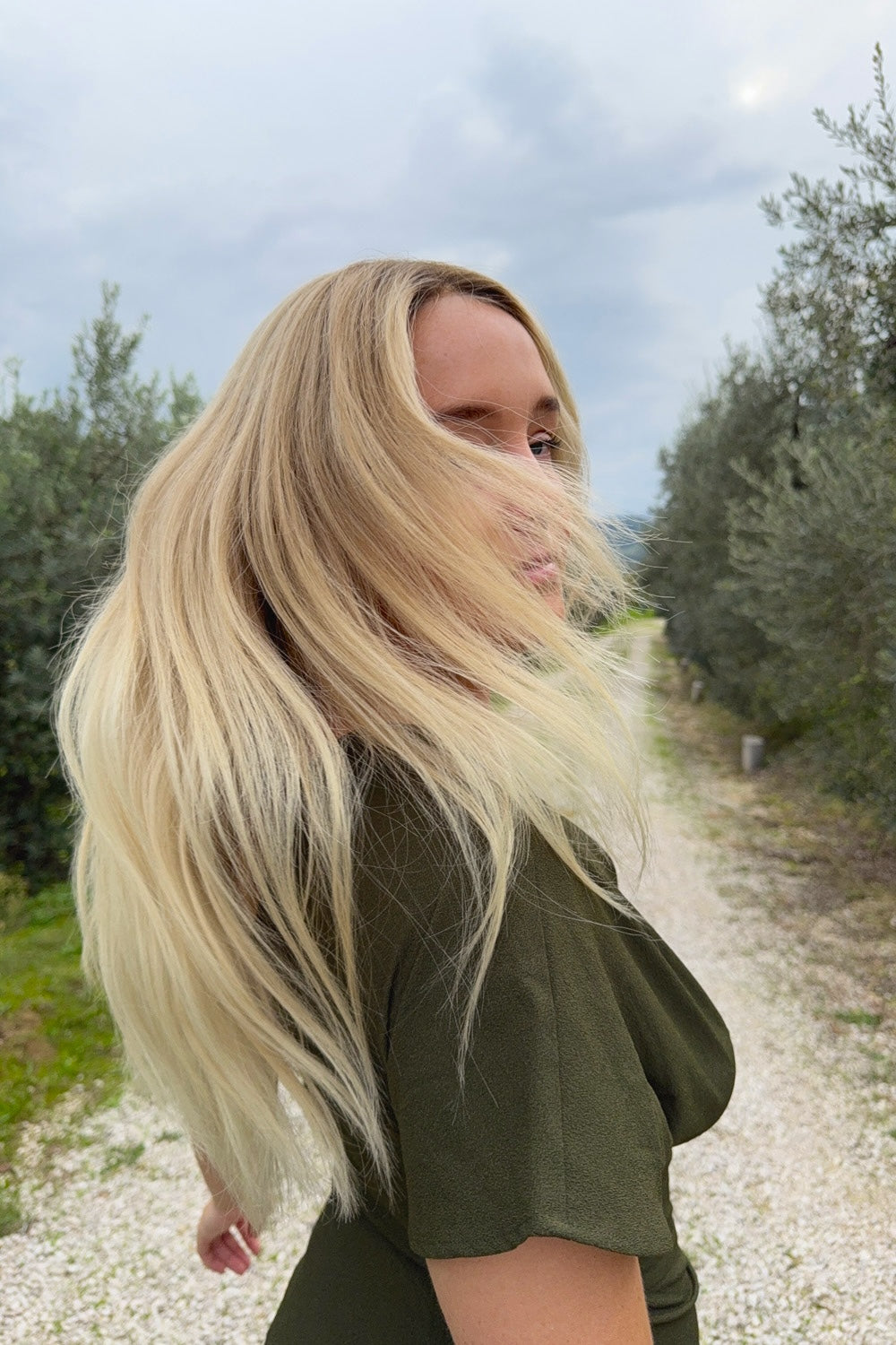 Woman wearing a BHBD Vera wig. Long wig in blonde with subtle golden tones and a naturally darker roots.